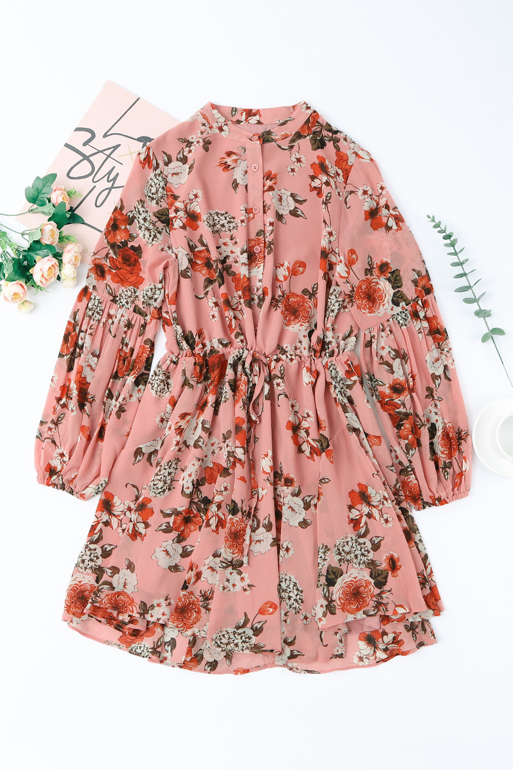 A stylish Floral Buttoned Puff Sleeve Tiered Dress featuring a floral pattern, balloon sleeves, and a mini length, displayed outdoors in a flat lay style.