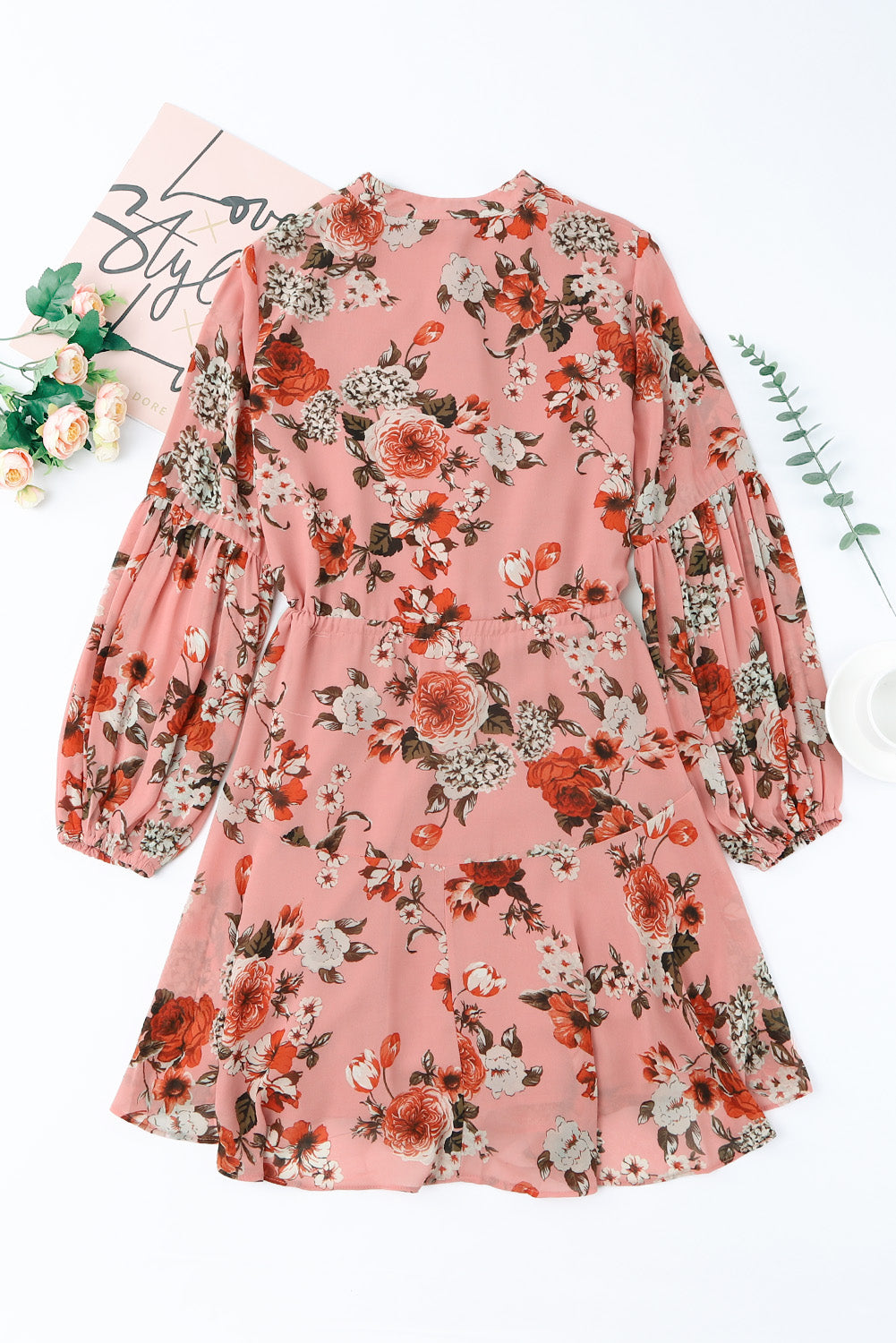 A stylish Floral Buttoned Puff Sleeve Tiered Dress featuring a floral pattern, balloon sleeves, and a mini length, displayed outdoors in a flat lay style.