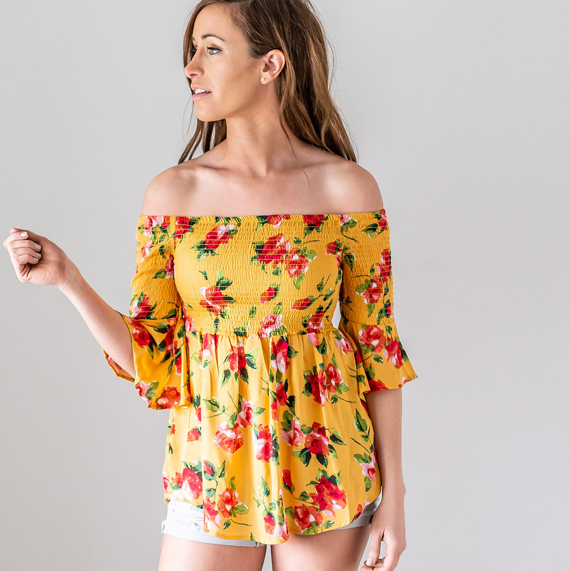 A lightweight floral print top featuring a baby doll silhouette and three-quarter bell sleeves, perfect for spring fashion.