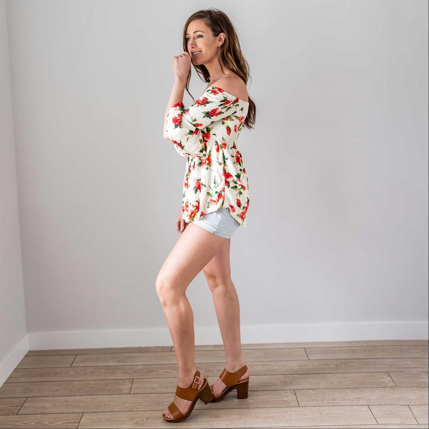 A lightweight floral print top featuring a baby doll silhouette and three-quarter bell sleeves, perfect for spring fashion.