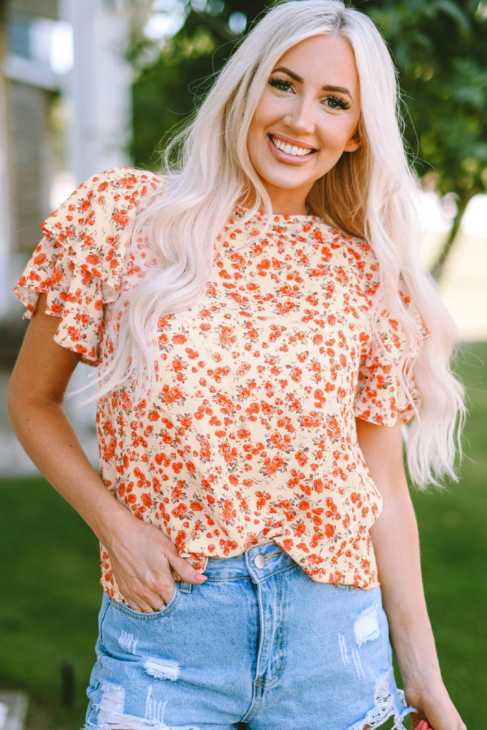 A stylish Floral Tiered Flutter Sleeve Blouse featuring a vibrant floral pattern, flutter sleeves, and a classic crew neckline, perfect for sunny days.