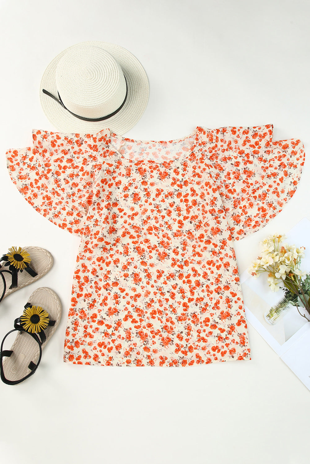 A stylish Floral Tiered Flutter Sleeve Blouse featuring a vibrant floral pattern, flutter sleeves, and a classic crew neckline, perfect for sunny days.