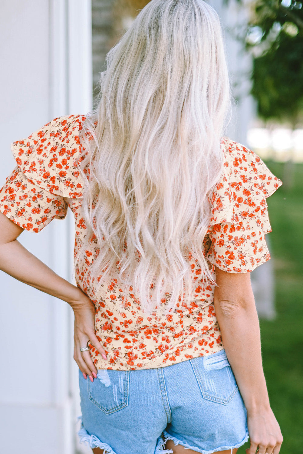 A stylish Floral Tiered Flutter Sleeve Blouse featuring a vibrant floral pattern, flutter sleeves, and a classic crew neckline, perfect for sunny days.