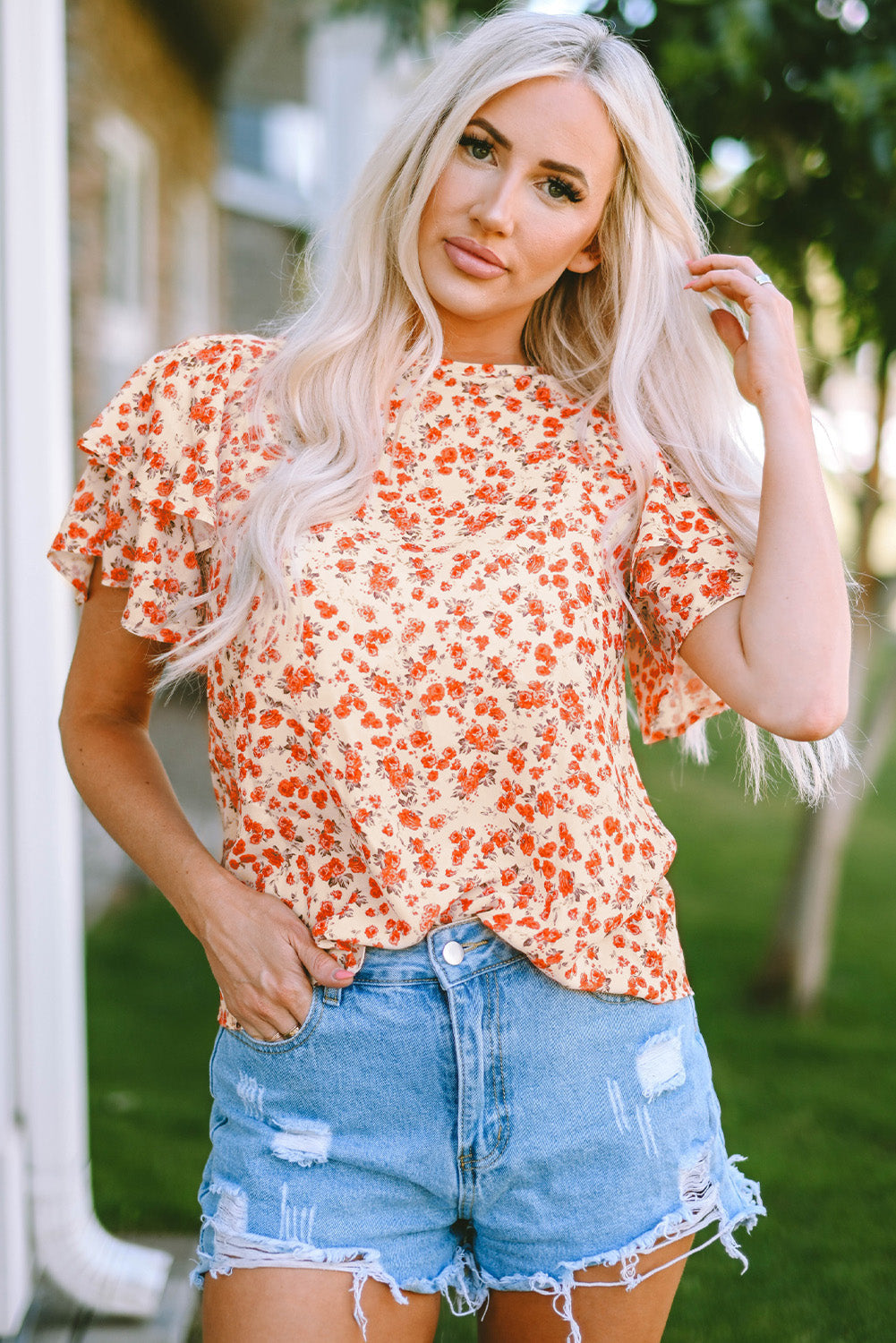 A stylish Floral Tiered Flutter Sleeve Blouse featuring a vibrant floral pattern, flutter sleeves, and a classic crew neckline, perfect for sunny days.