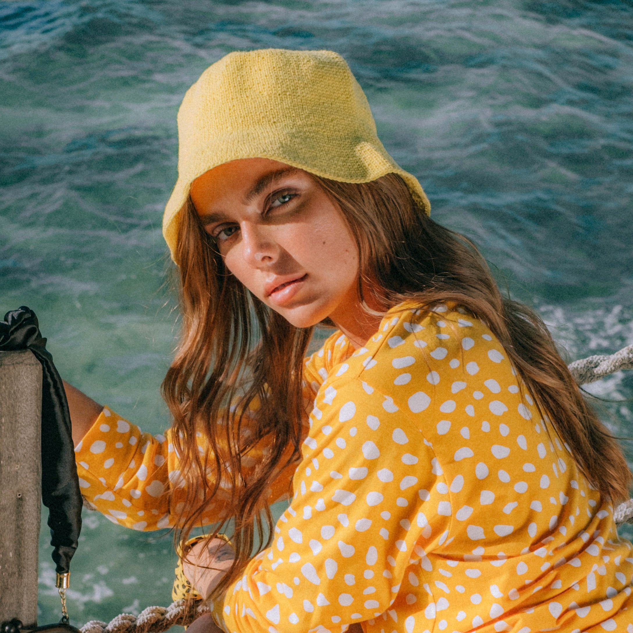 FLORETTE Crochet Bucket Hat in vibrant yellow, handcrafted from soft cotton yarn, featuring a flexible fit and stylish 2-inch brim.