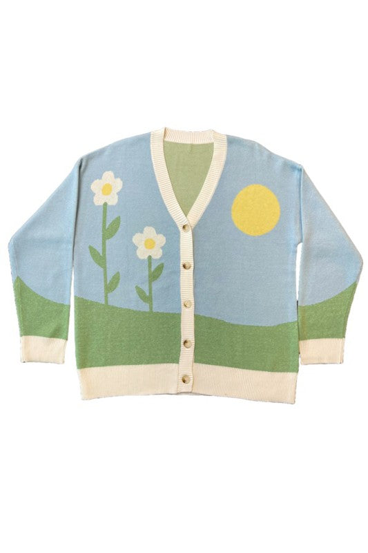 A stylish Flower Field Knit Cardigan featuring a vibrant flower field and sun intarsia design, button front, and V neckline.