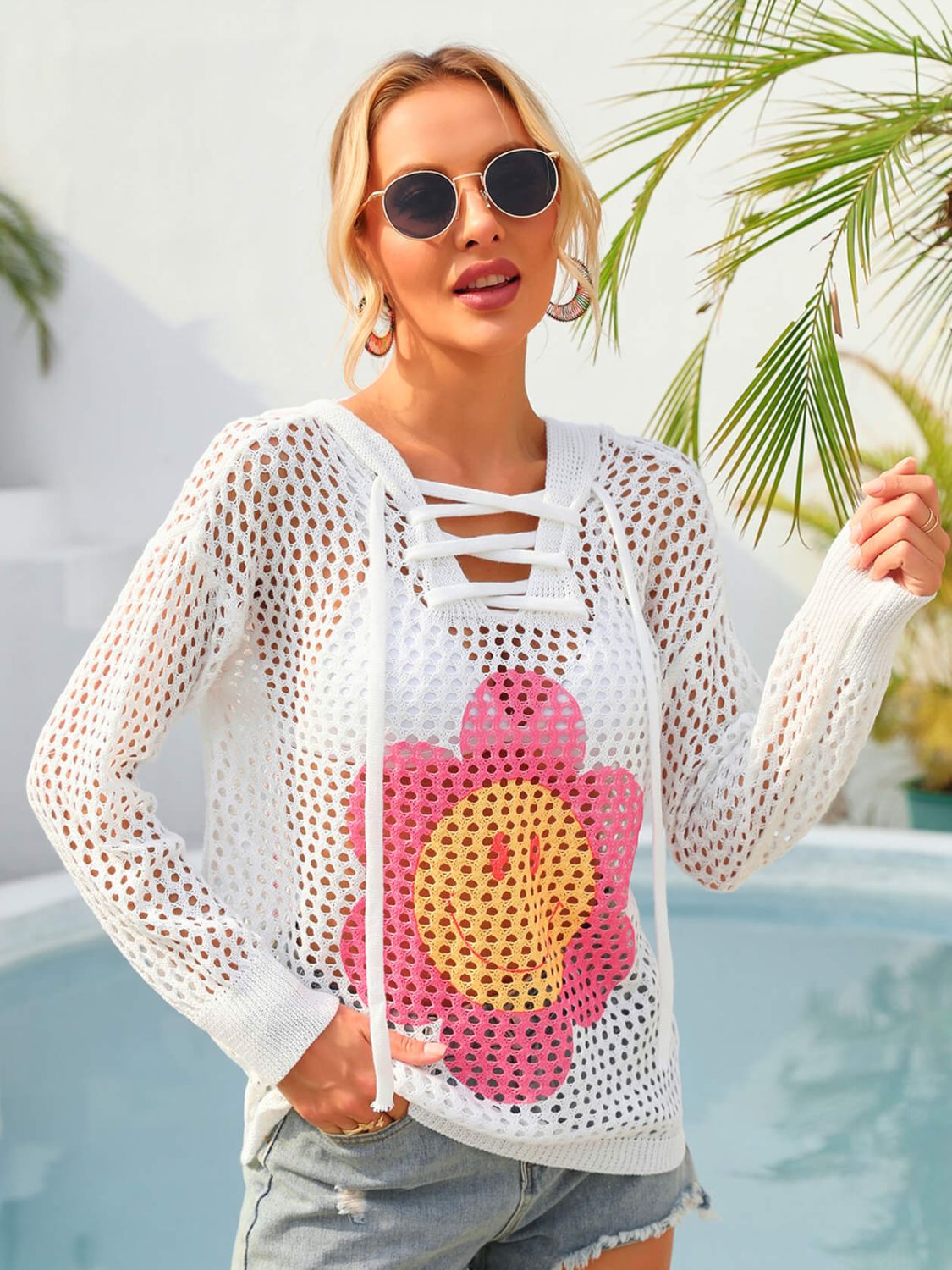 A stylish Flower Graphic Lace-Up Openwork Hooded Cover Up featuring a floral pattern, lace-up design, and hooded neckline, perfect for layering.