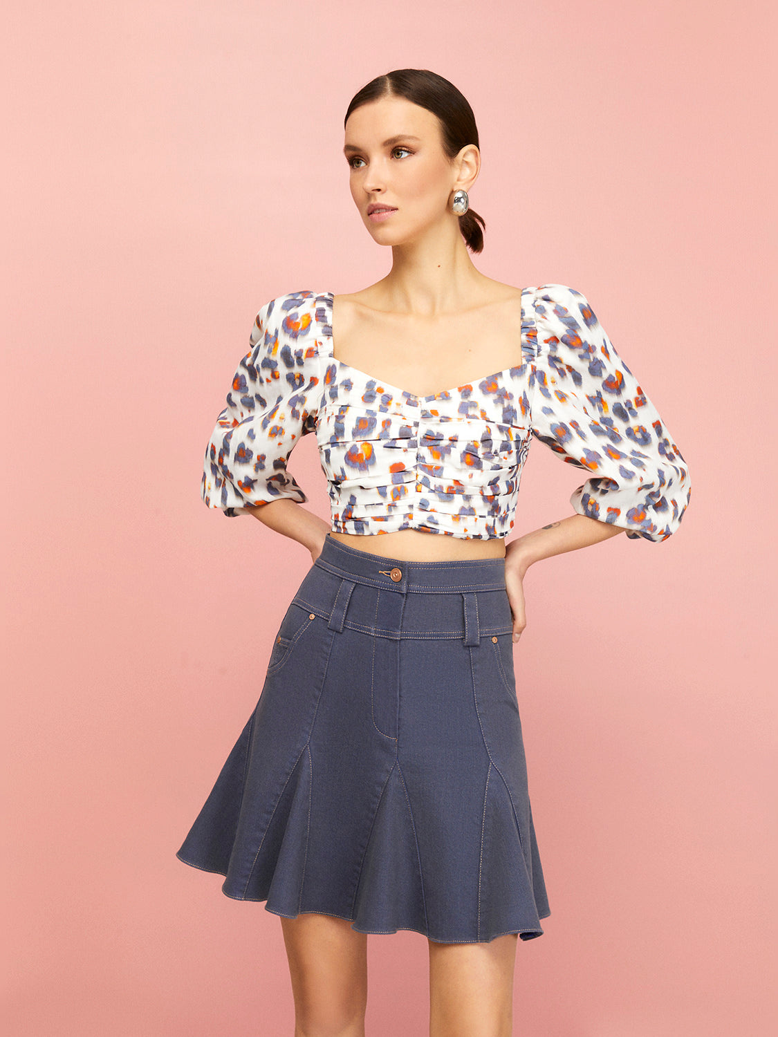 Flowing Mini Jean Skirt featuring a high-waisted design, flounced hem, and unique leopard print with orange accents.