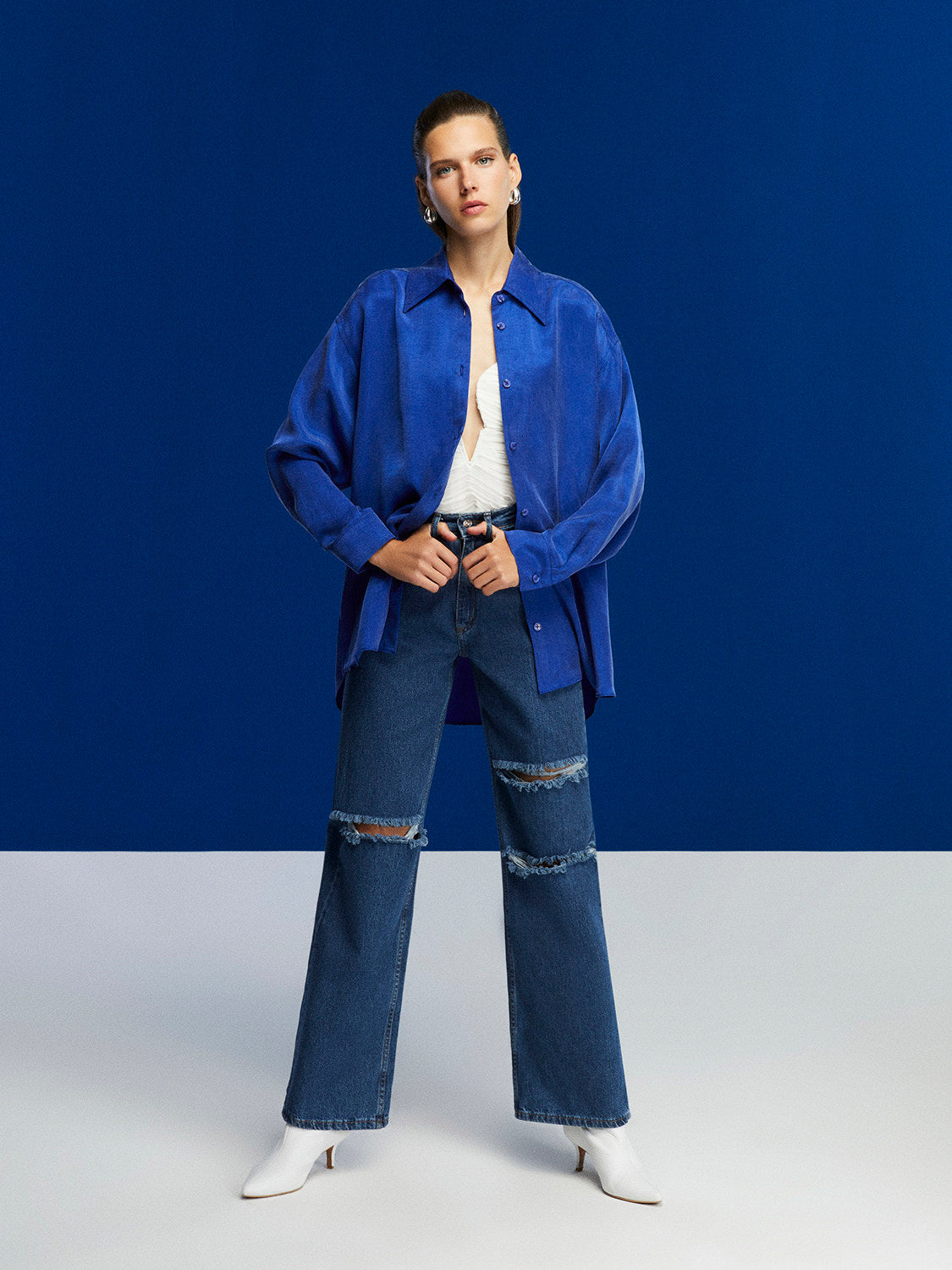 Flowy oversized shirt with lapel collar, front buttons, and long sleeves, featuring vibrant colors and a relaxed fit.