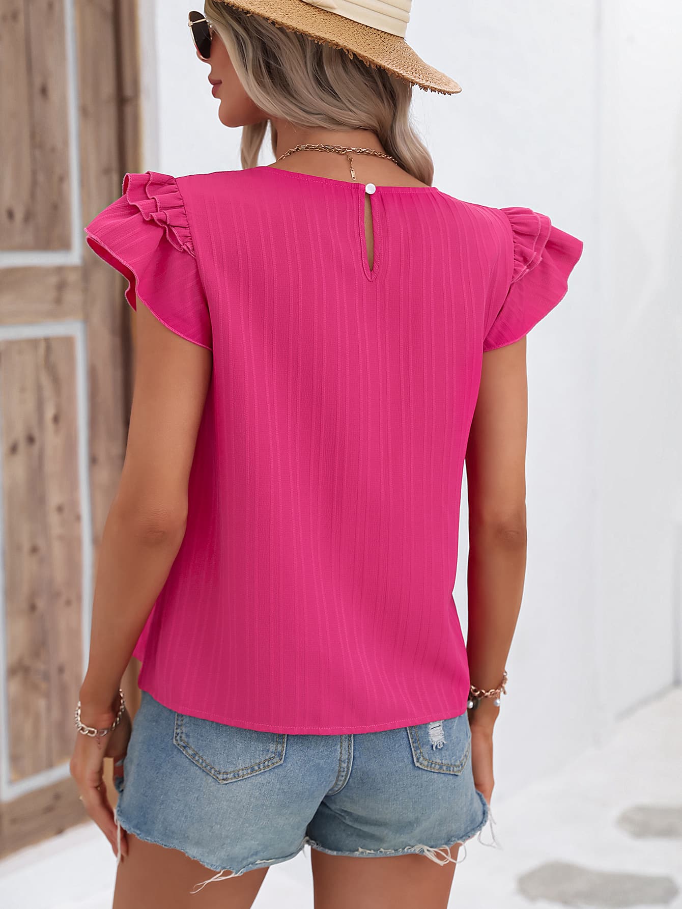 A stylish Flutter Sleeve Round Neck Blouse featuring chic ruffles and cap sleeves, made from 100% polyester in a solid color.