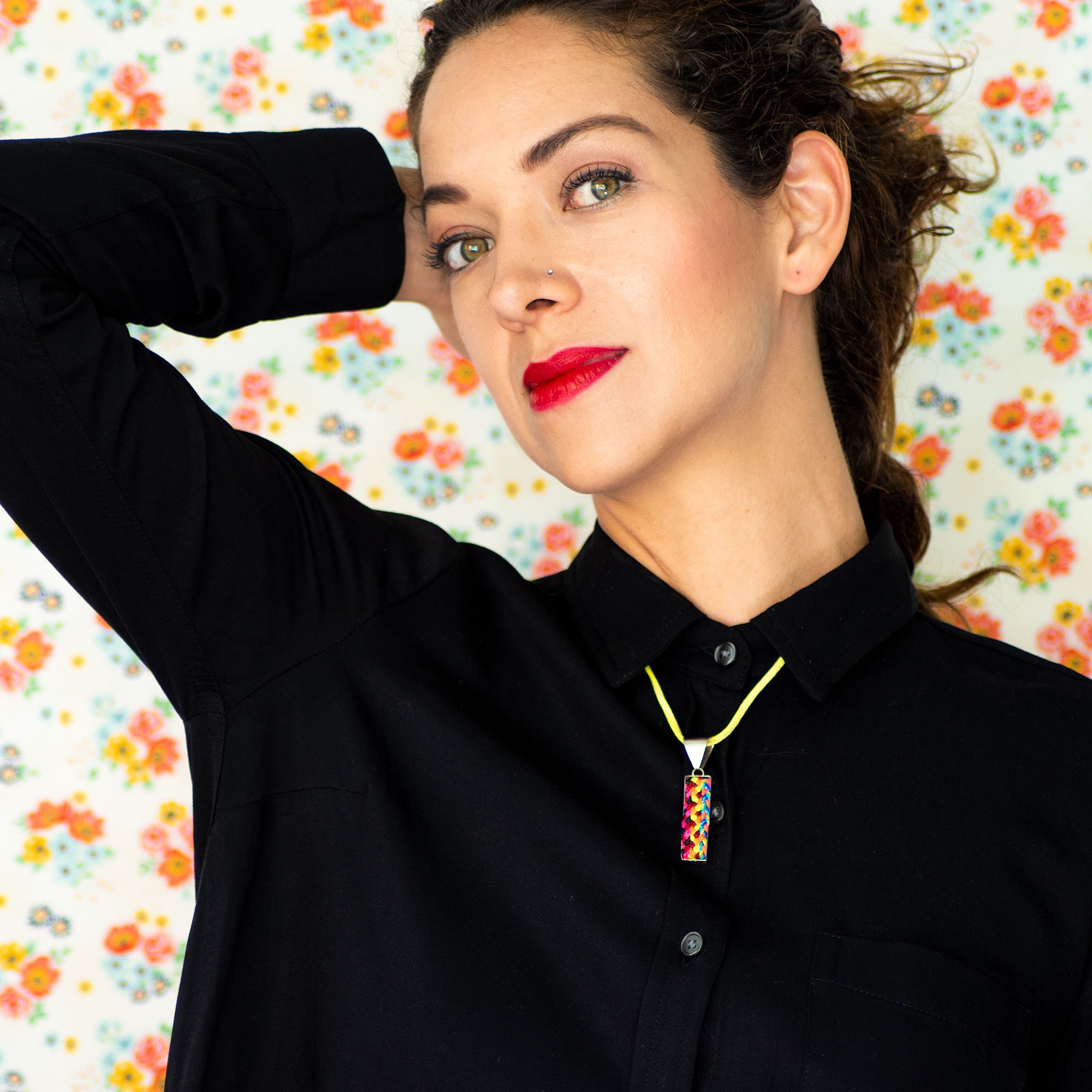 A colorful Folk Long Pendant Necklace featuring unique hand-embroidered patterns by artisans from Chiapas, Mexico, displayed elegantly on a neutral background.