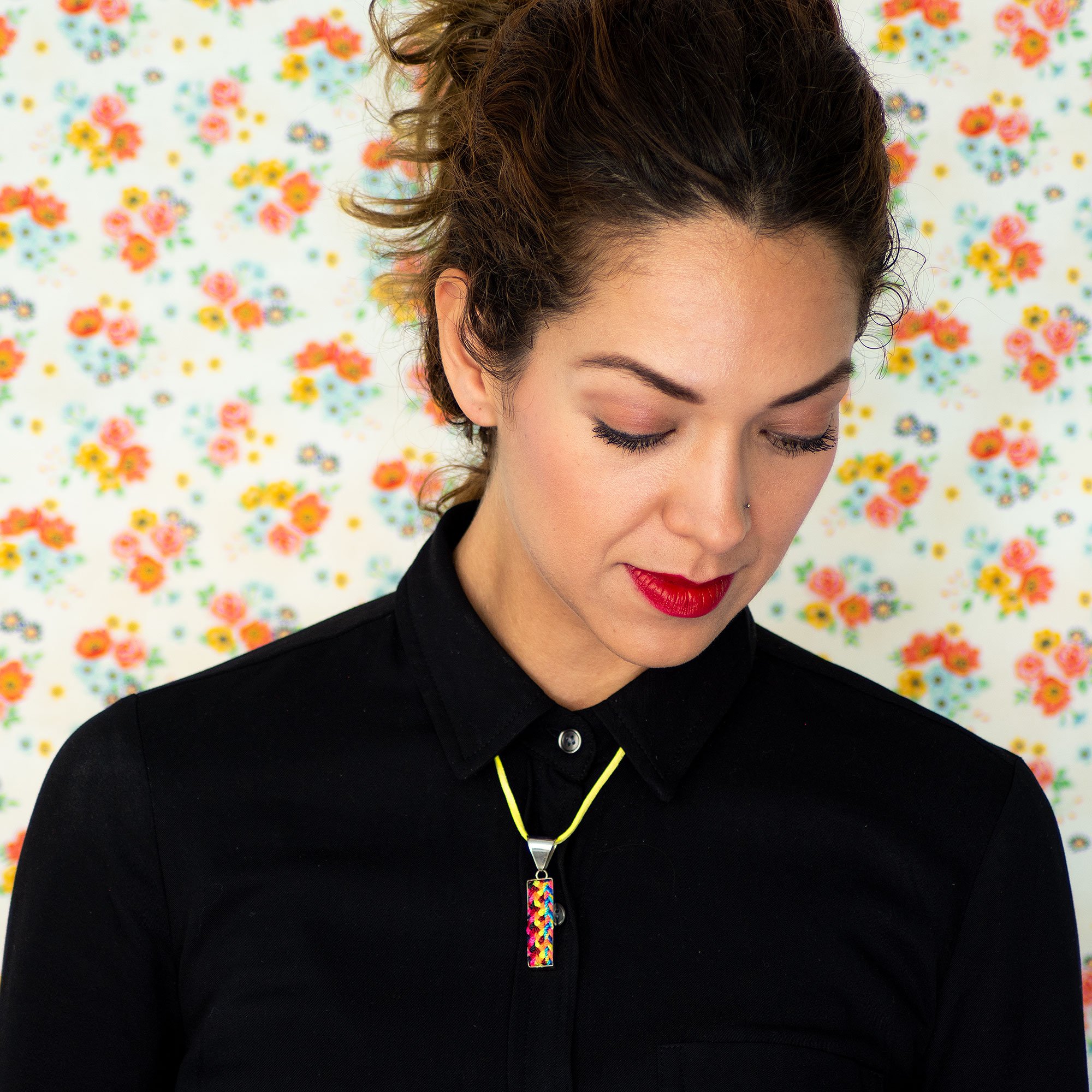 A colorful Folk Long Pendant Necklace featuring unique hand-embroidered patterns by artisans from Chiapas, Mexico, displayed elegantly on a neutral background.