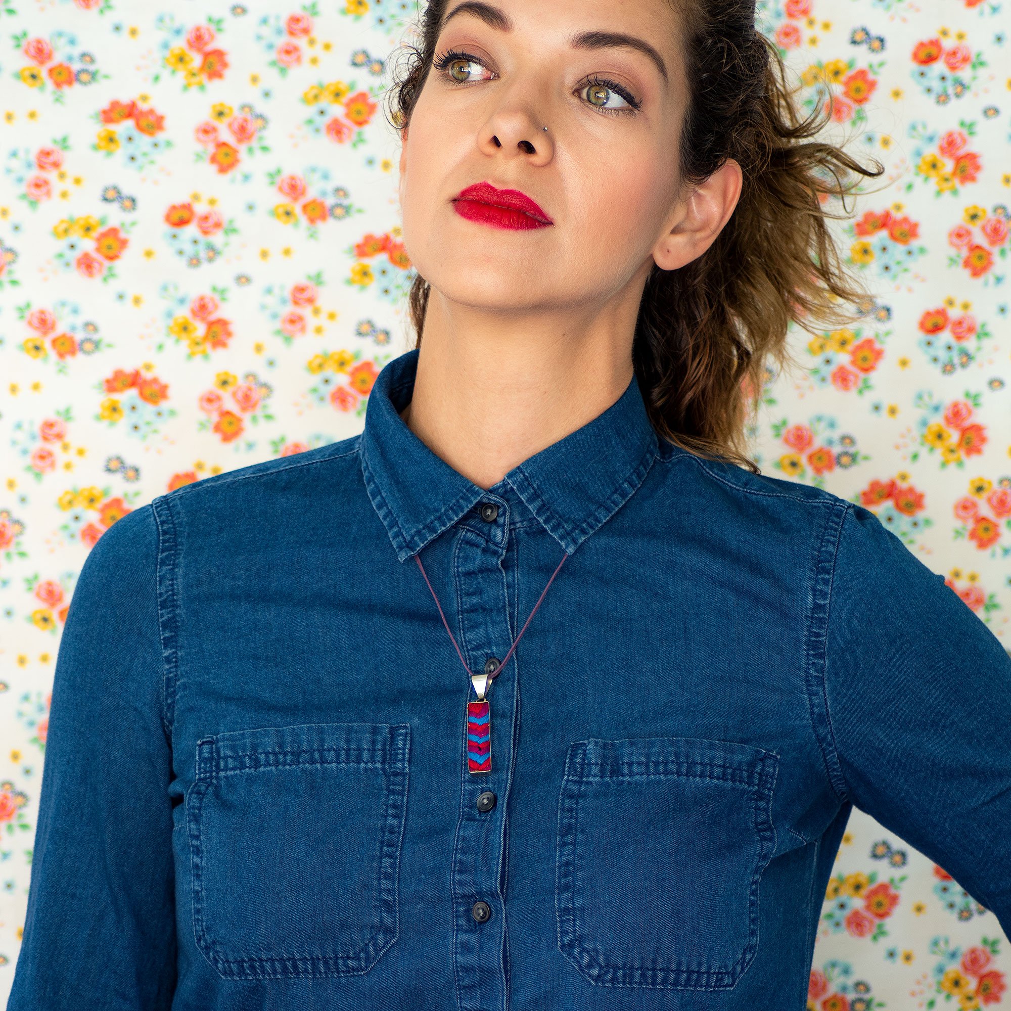 A colorful Folk Long Pendant Necklace featuring unique hand-embroidered patterns by artisans from Chiapas, Mexico, displayed elegantly on a neutral background.