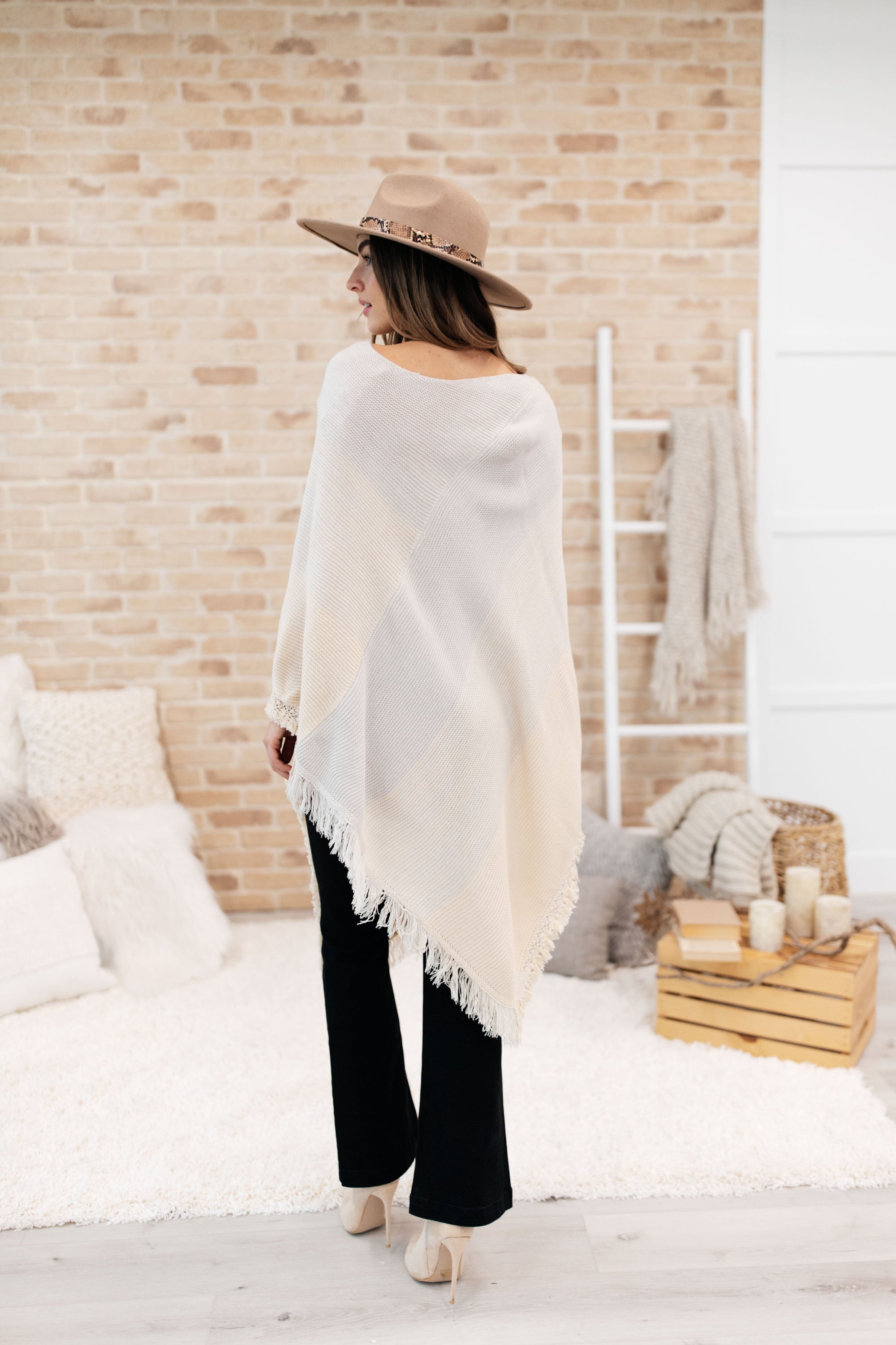 A stylish grey poncho with a color-blocked design and fringed edges, perfect for chilly days and cozy movie nights.