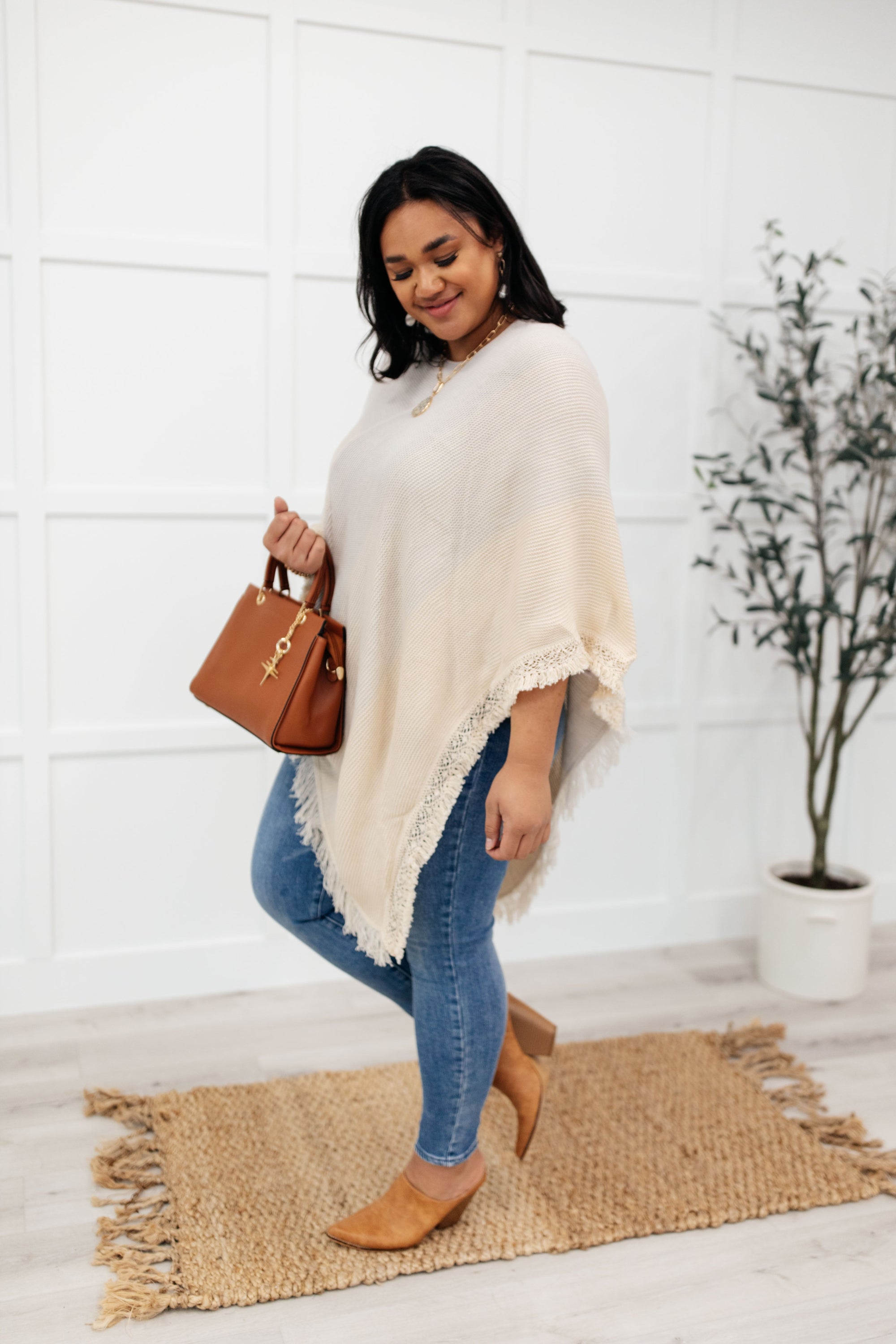 A stylish grey poncho with a color-blocked design and fringed edges, perfect for chilly days and cozy movie nights.