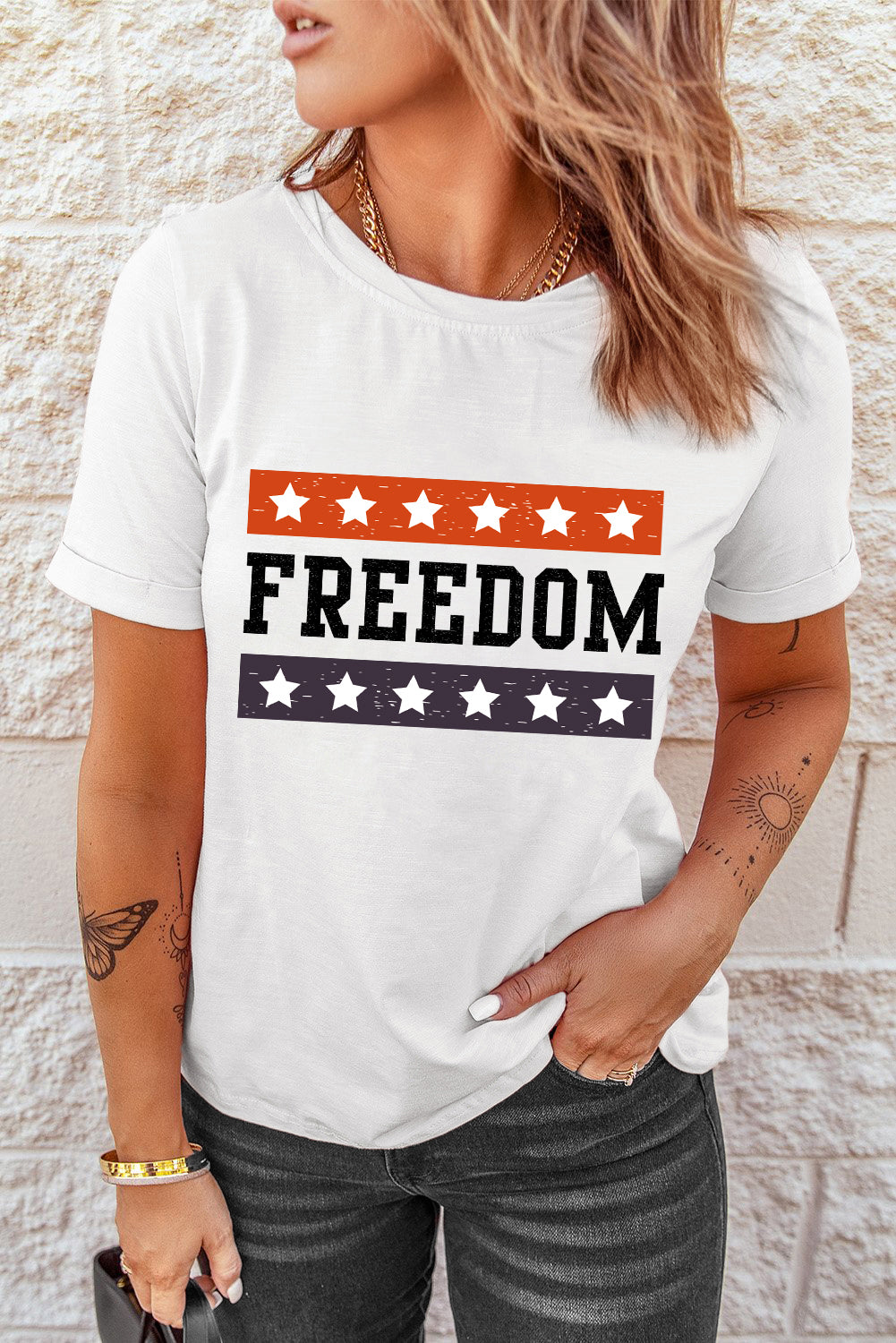 FREEDOM Graphic Cuffed Sleeve Tee featuring a stylish DTG graphic design, round neckline, and short cuffed sleeves.