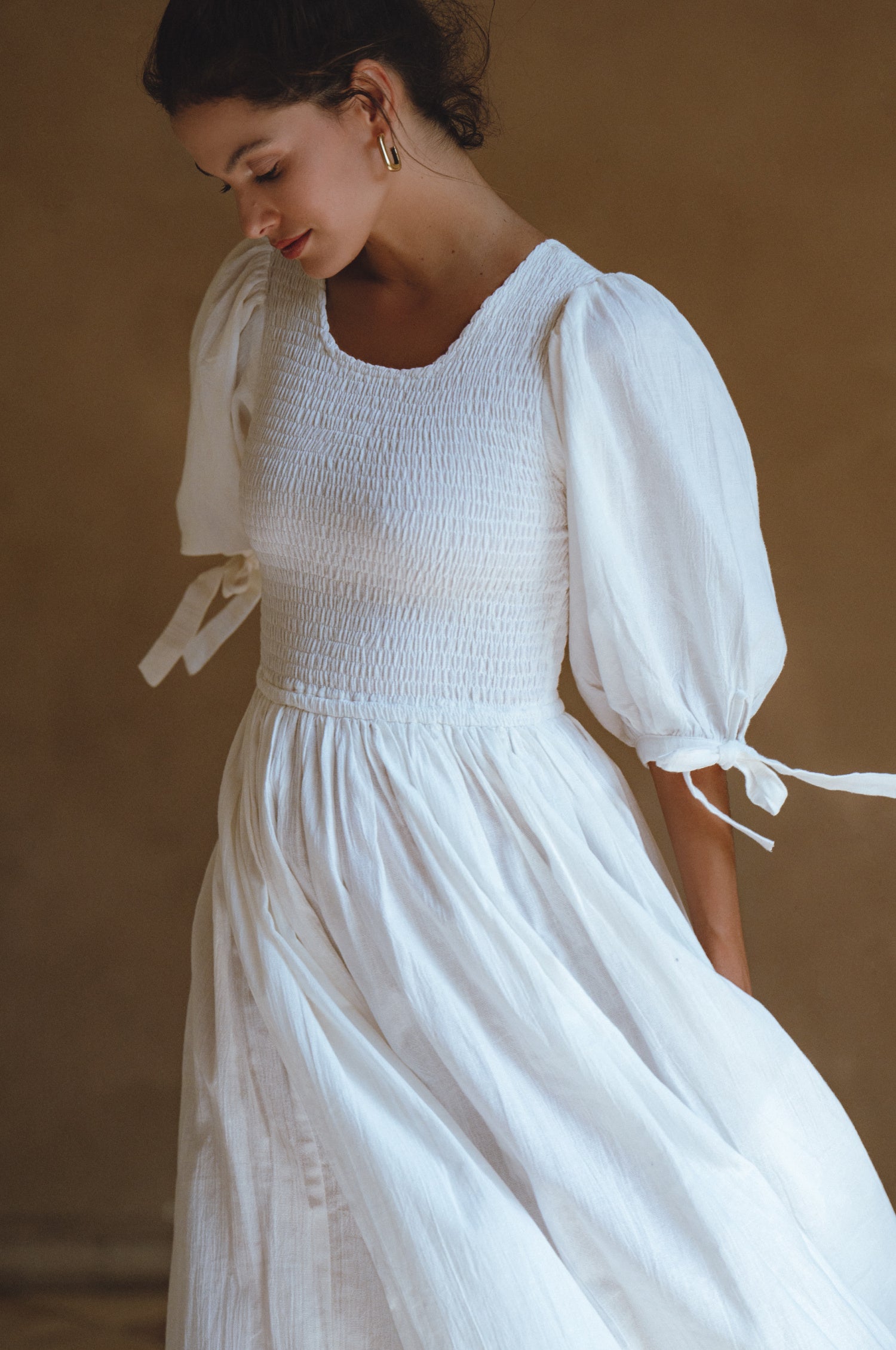 Freya Smocked Linen Midi Dress featuring a smocked bodice and tie-up puffy sleeves in a light crinkle linen fabric.