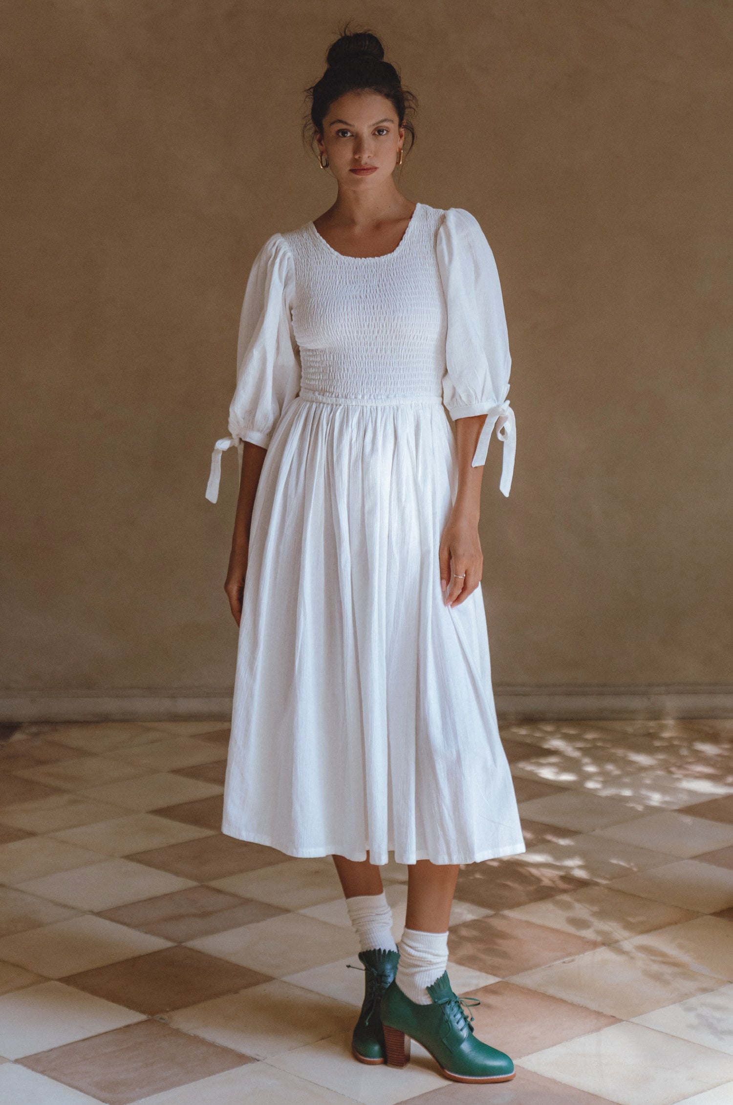 Freya Smocked Linen Midi Dress featuring a smocked bodice and tie-up puffy sleeves in a light crinkle linen fabric.