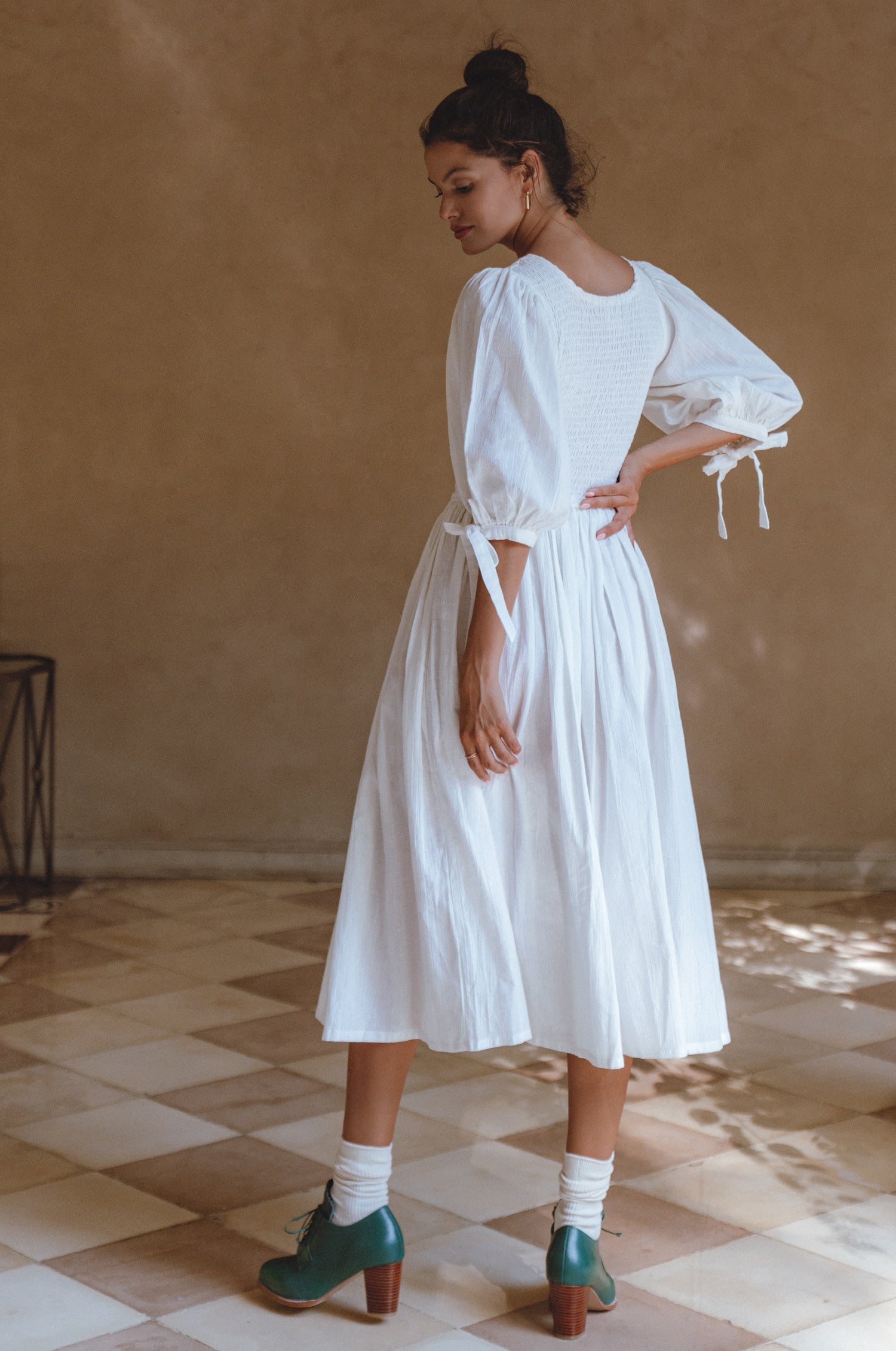 Freya Smocked Linen Midi Dress featuring a smocked bodice and tie-up puffy sleeves in a light crinkle linen fabric.