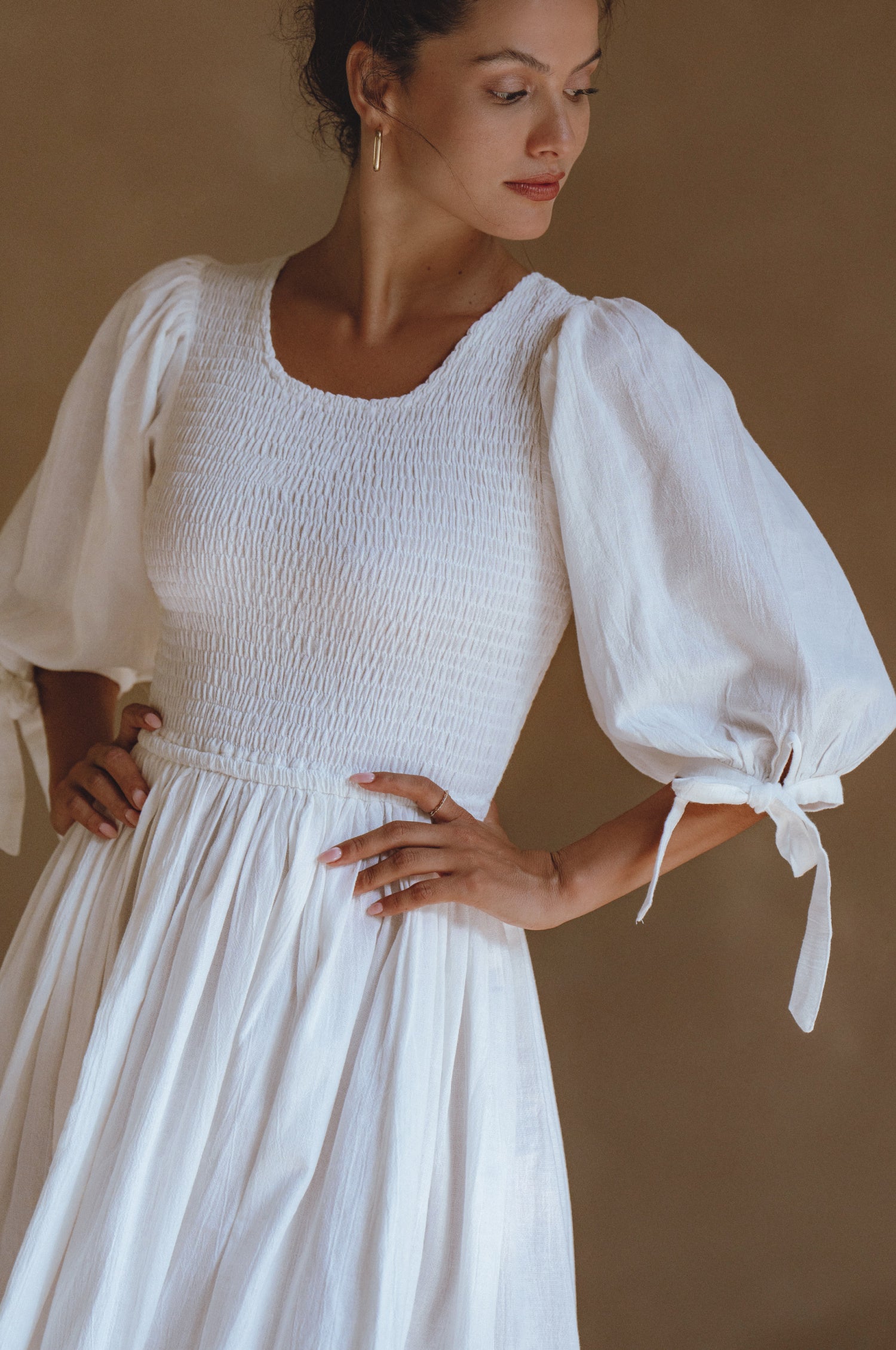 Freya Smocked Linen Midi Dress featuring a smocked bodice and tie-up puffy sleeves in a light crinkle linen fabric.