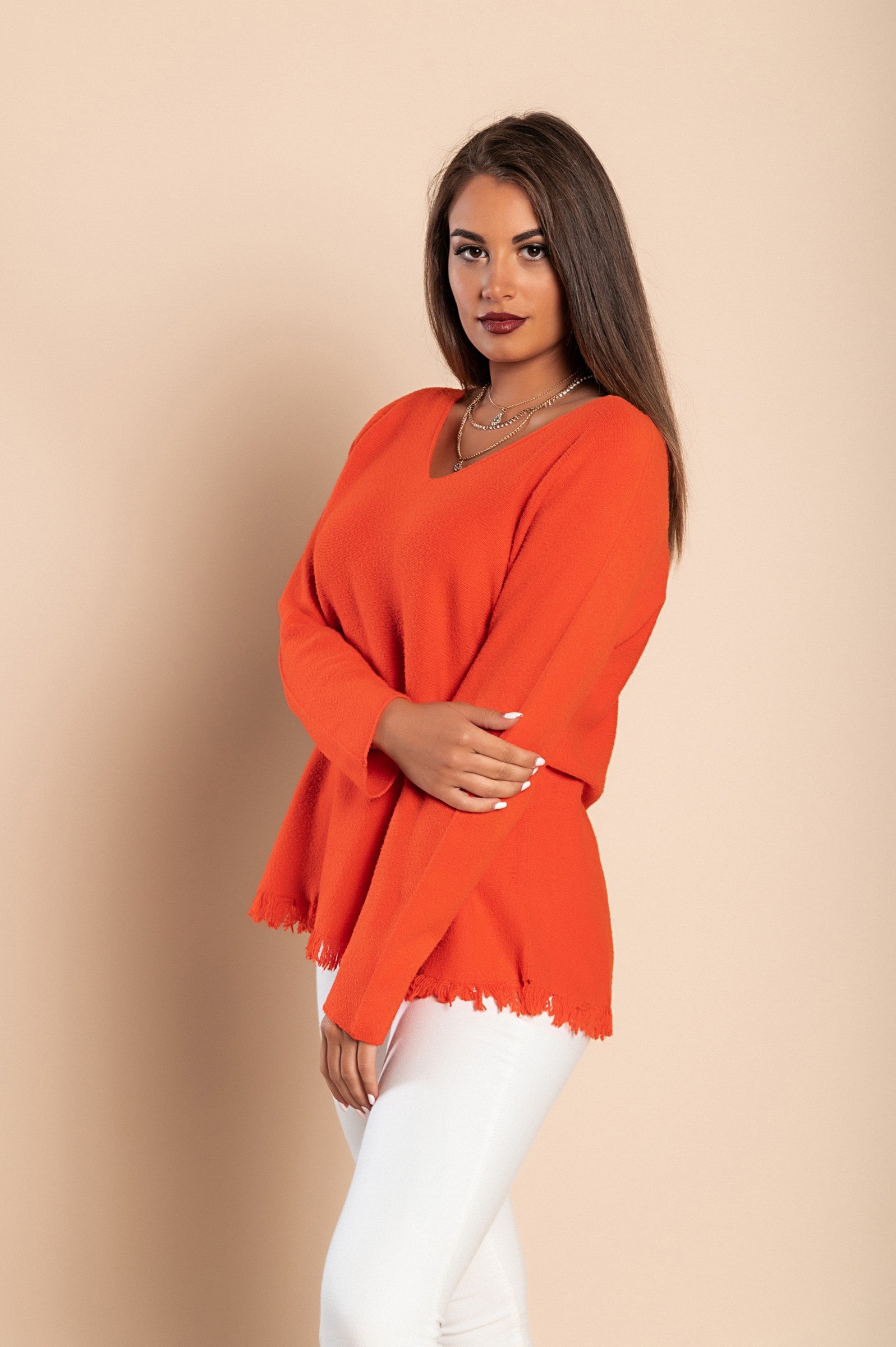 Stylish orange fringed jumper with V-neckline and long sleeves, showcasing a soft knitwear texture.