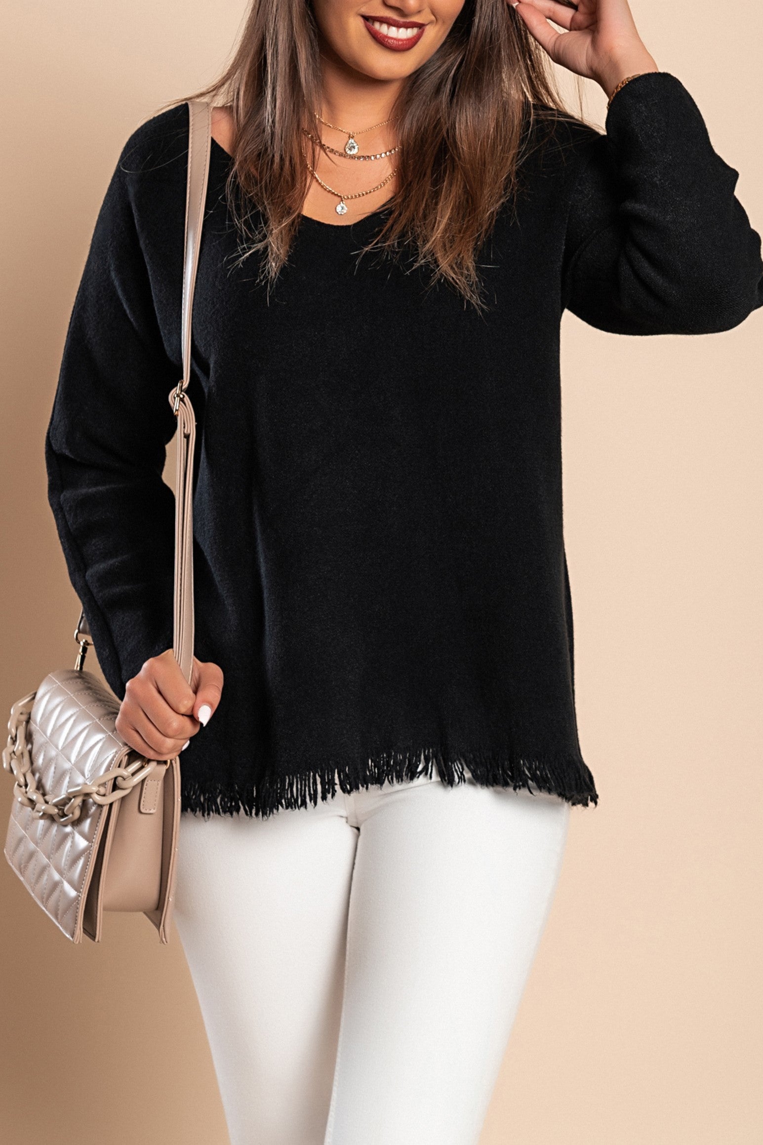 A stylish black fringed sweater featuring a V-neckline and long sleeves, made from soft knitwear.