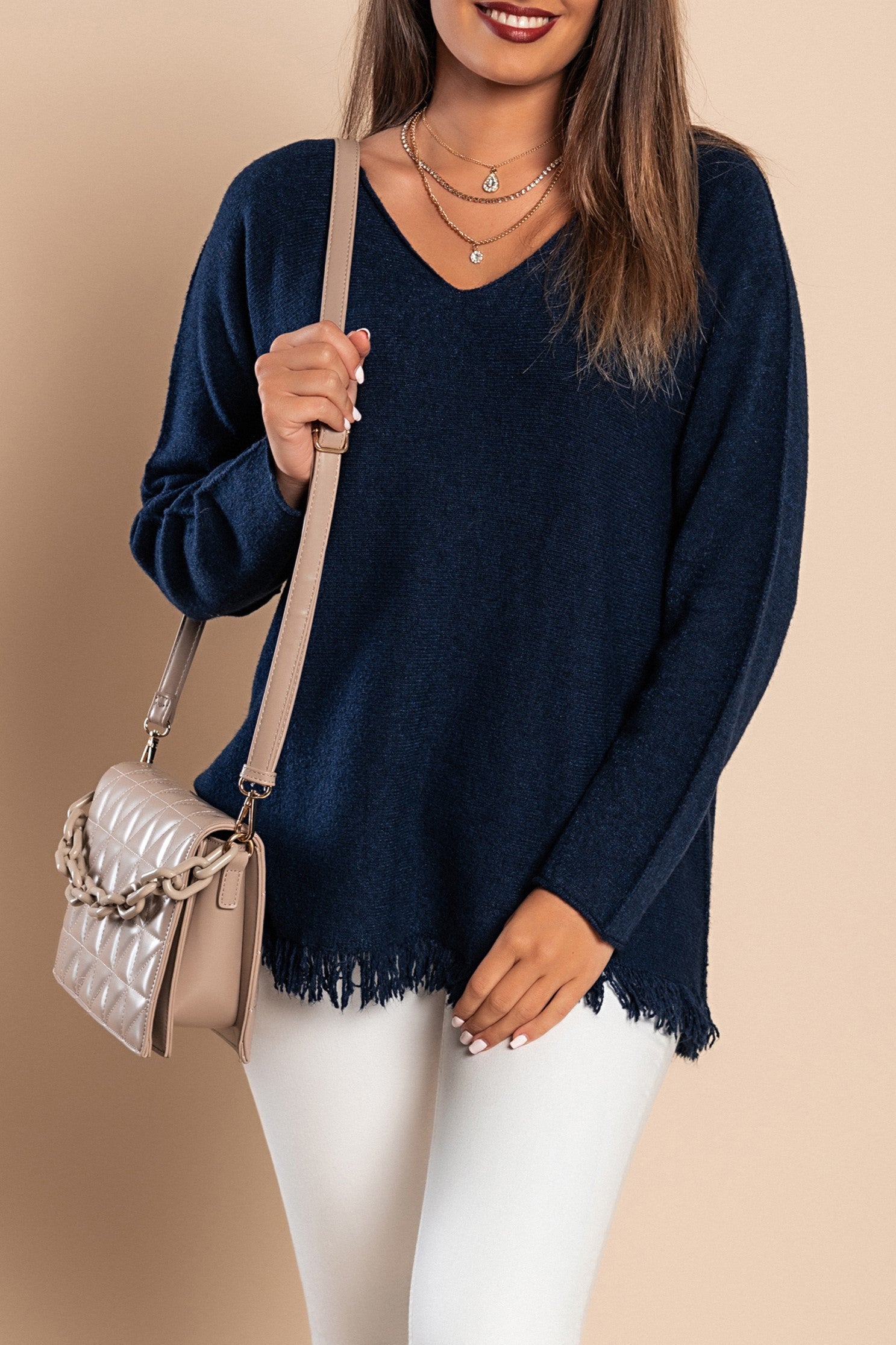 A stylish dark blue fringed sweater featuring long sleeves and a V-neckline, made from soft knitwear.