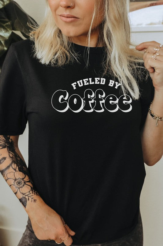 A stylish Fueled By Coffee Graphic Tee featuring a trendy coffee-themed design on a soft, lightweight fabric.