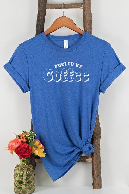 A stylish Fueled By Coffee Graphic Tee featuring a trendy coffee-themed design on a soft, lightweight fabric.