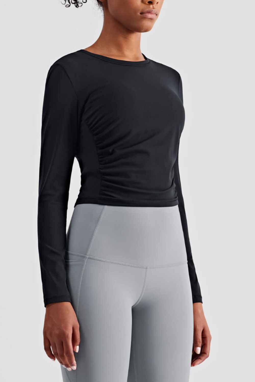 Gathered Detail Long Sleeve Sports Top in a studio setting, showcasing its solid pattern and comfortable fit.