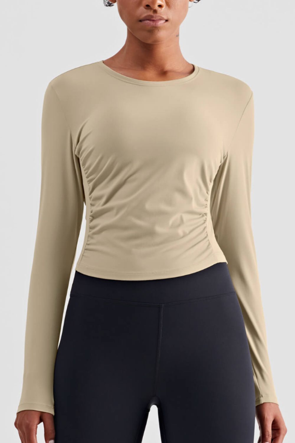 Gathered Detail Long Sleeve Sports Top in a studio setting, showcasing its solid pattern and comfortable fit.