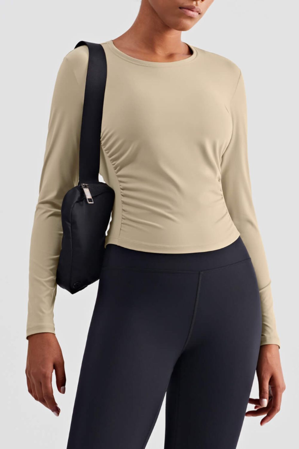 Gathered Detail Long Sleeve Sports Top in a studio setting, showcasing its solid pattern and comfortable fit.