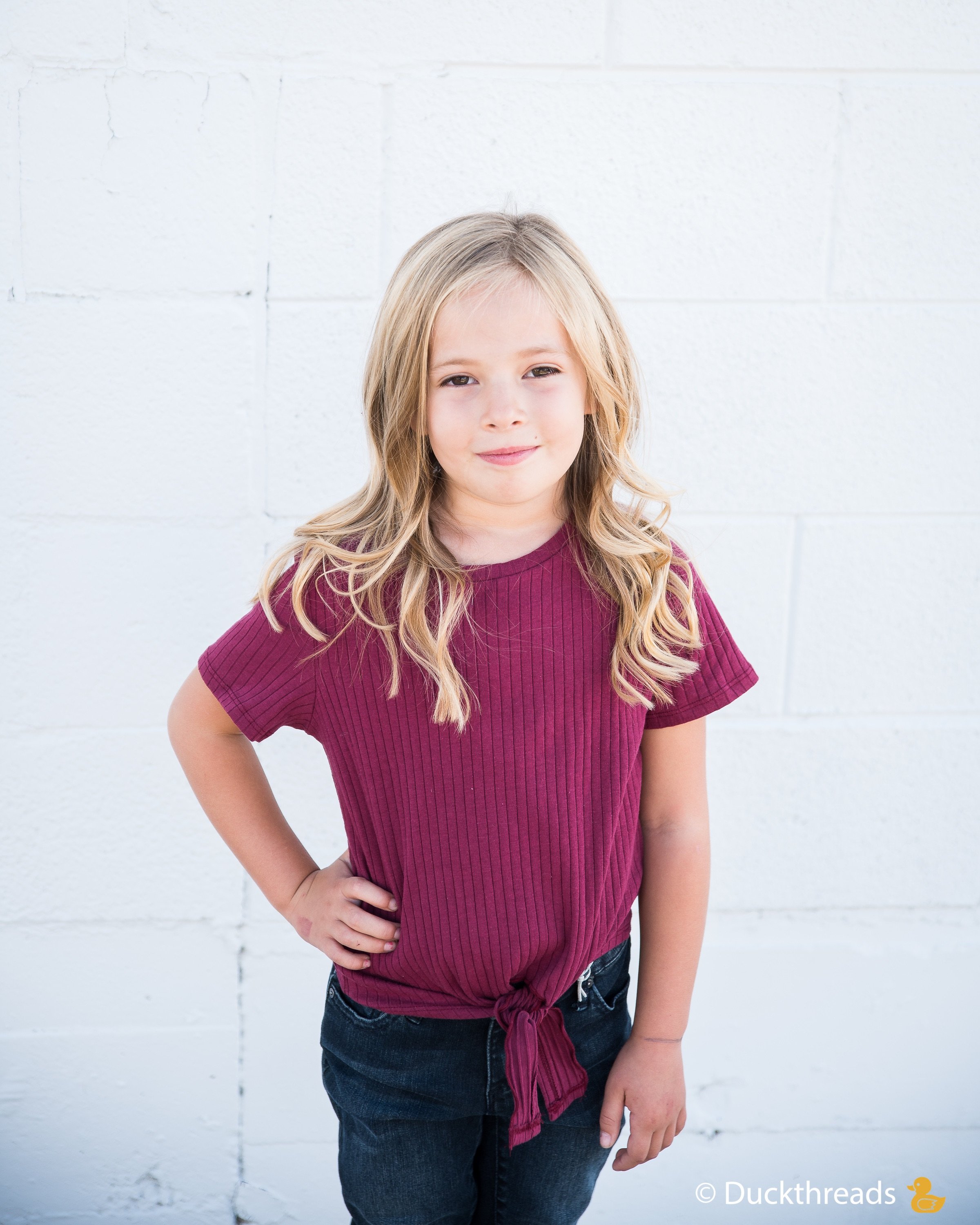 Girls Ribbed Tie Bottom Tee in Pink and Burgundy, showcasing soft ribbed fabric and stylish tie bottom design.