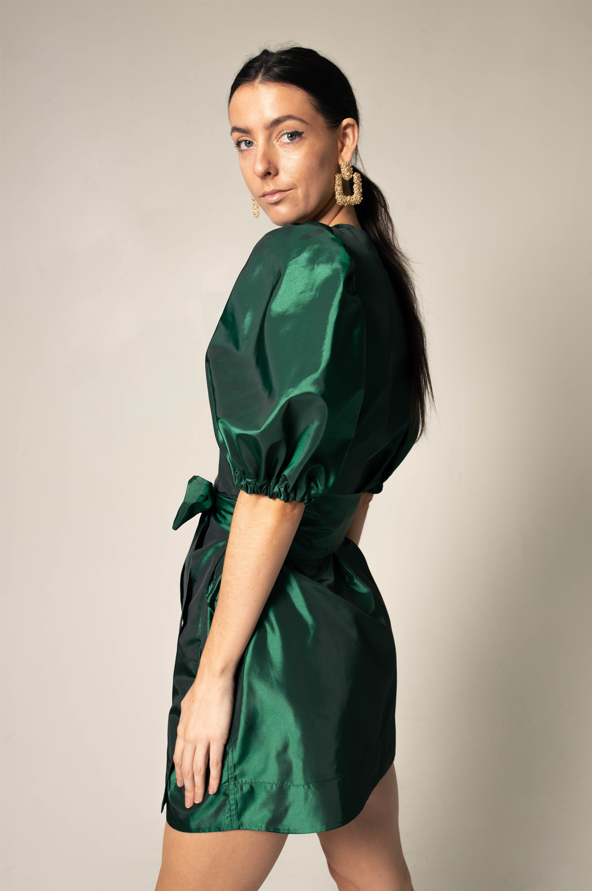 A luxurious green wrap dress from Le Réussi, showcasing its elegant design and plush fabric, perfect for work or cocktail events.