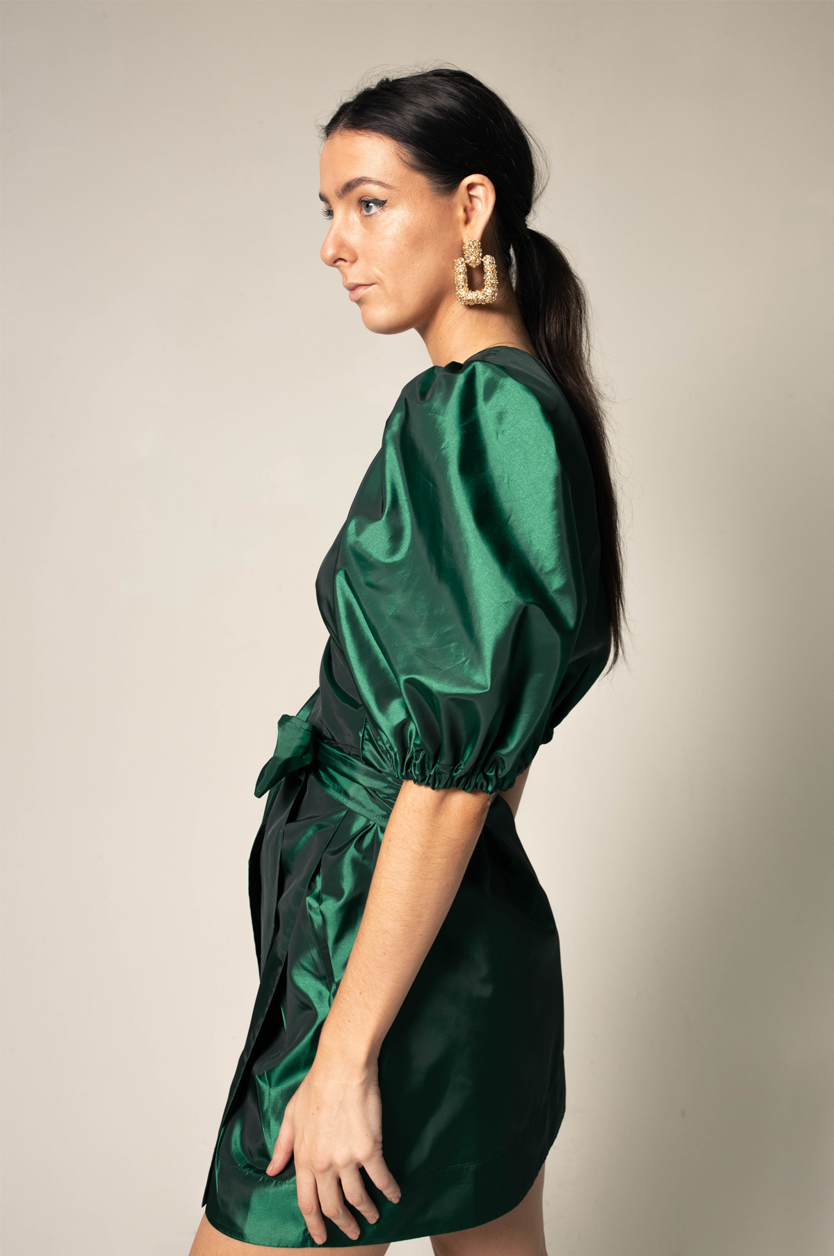 A luxurious green wrap dress from Le Réussi, showcasing its elegant design and plush fabric, perfect for work or cocktail events.