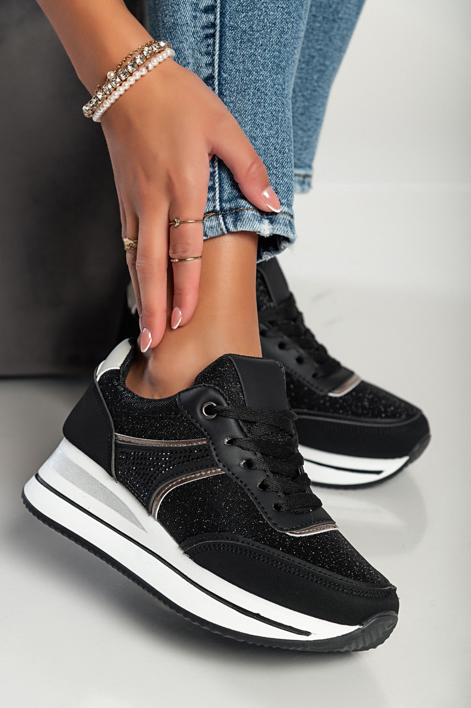 Black glitter fashion sneakers with raised sole and laces, showcasing a stylish round toe design.