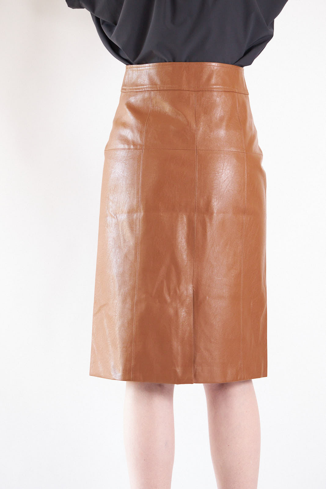 Glossy brown vegan leather pencil skirt with front button detail, knee-length design, and stylish silhouette.