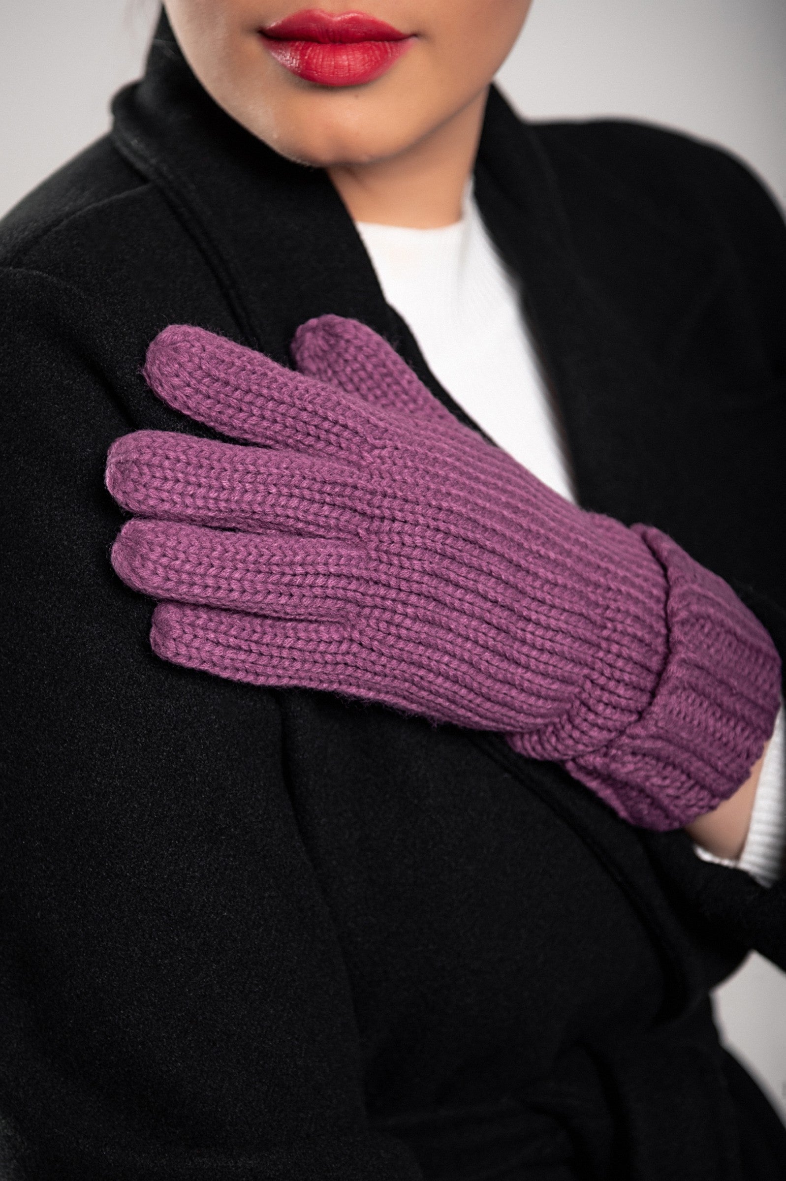 A pair of beautifully knitted violet gloves with a wide hem, showcasing their soft texture and stylish design.