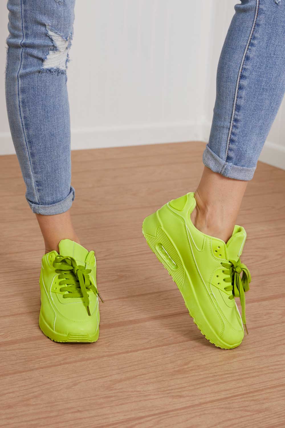 A pair of vibrant neon sneakers with a round toe and low heel, perfect for stylish outfits and active lifestyles.