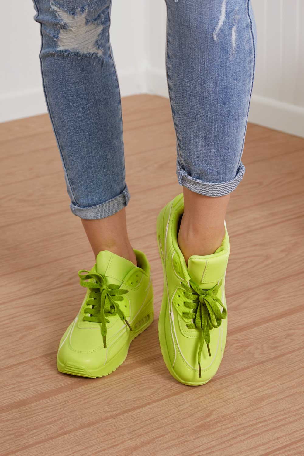 A pair of vibrant neon sneakers with a round toe and low heel, perfect for stylish outfits and active lifestyles.