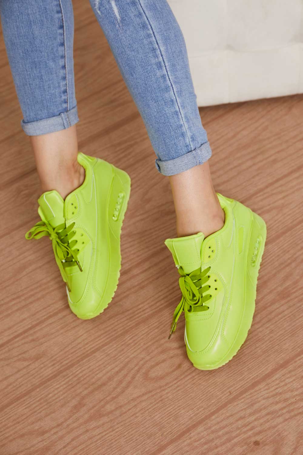 A pair of vibrant neon sneakers with a round toe and low heel, perfect for stylish outfits and active lifestyles.