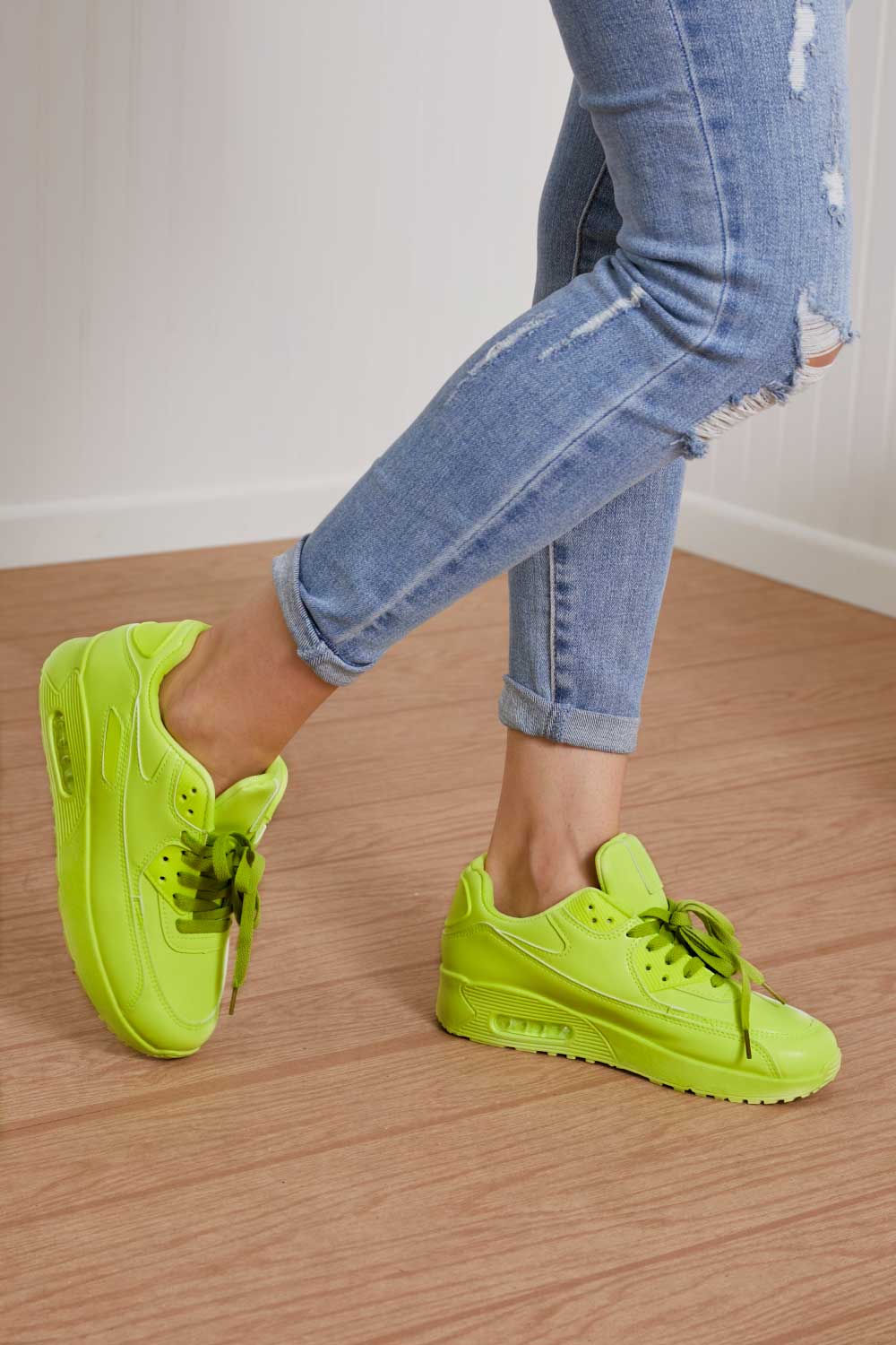 A pair of vibrant neon sneakers with a round toe and low heel, perfect for stylish outfits and active lifestyles.