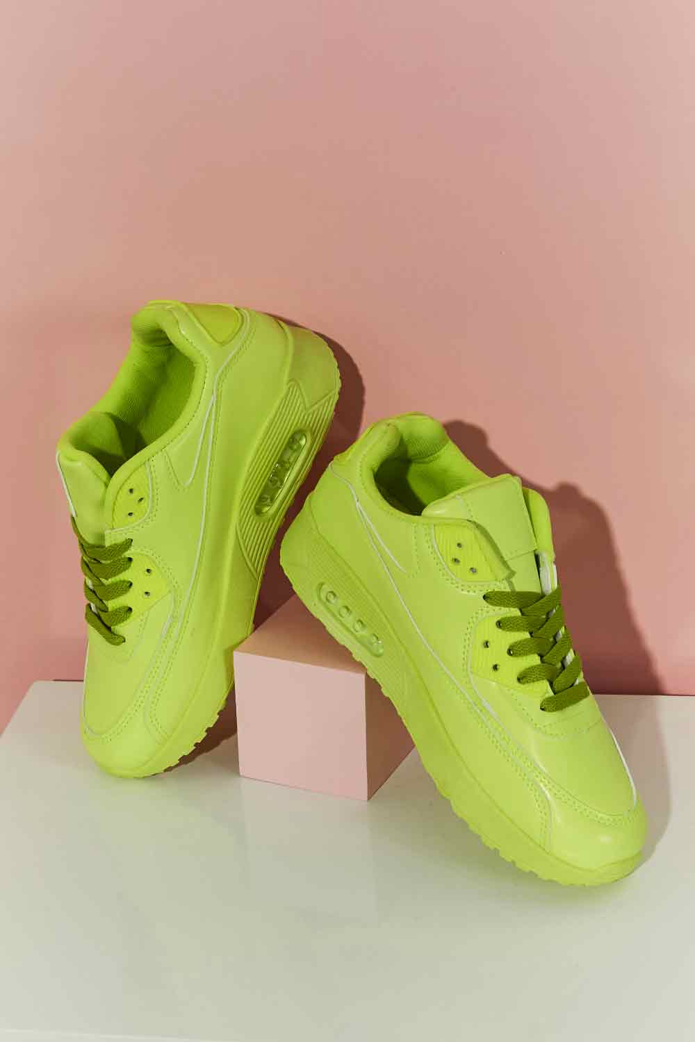 A pair of vibrant neon sneakers with a round toe and low heel, perfect for stylish outfits and active lifestyles.