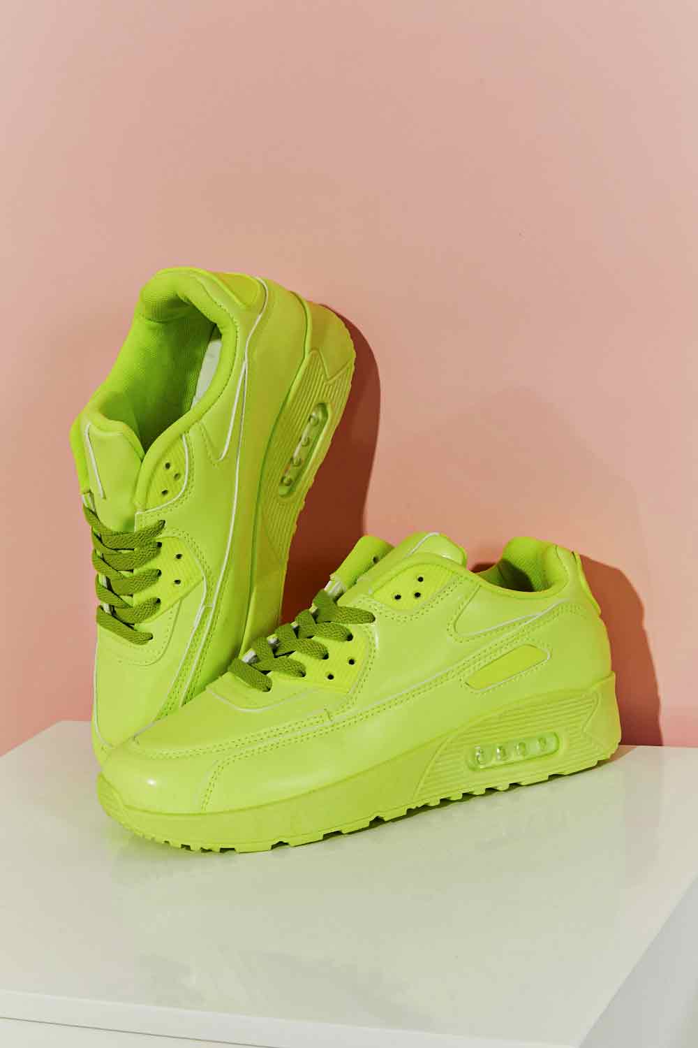 A pair of vibrant neon sneakers with a round toe and low heel, perfect for stylish outfits and active lifestyles.