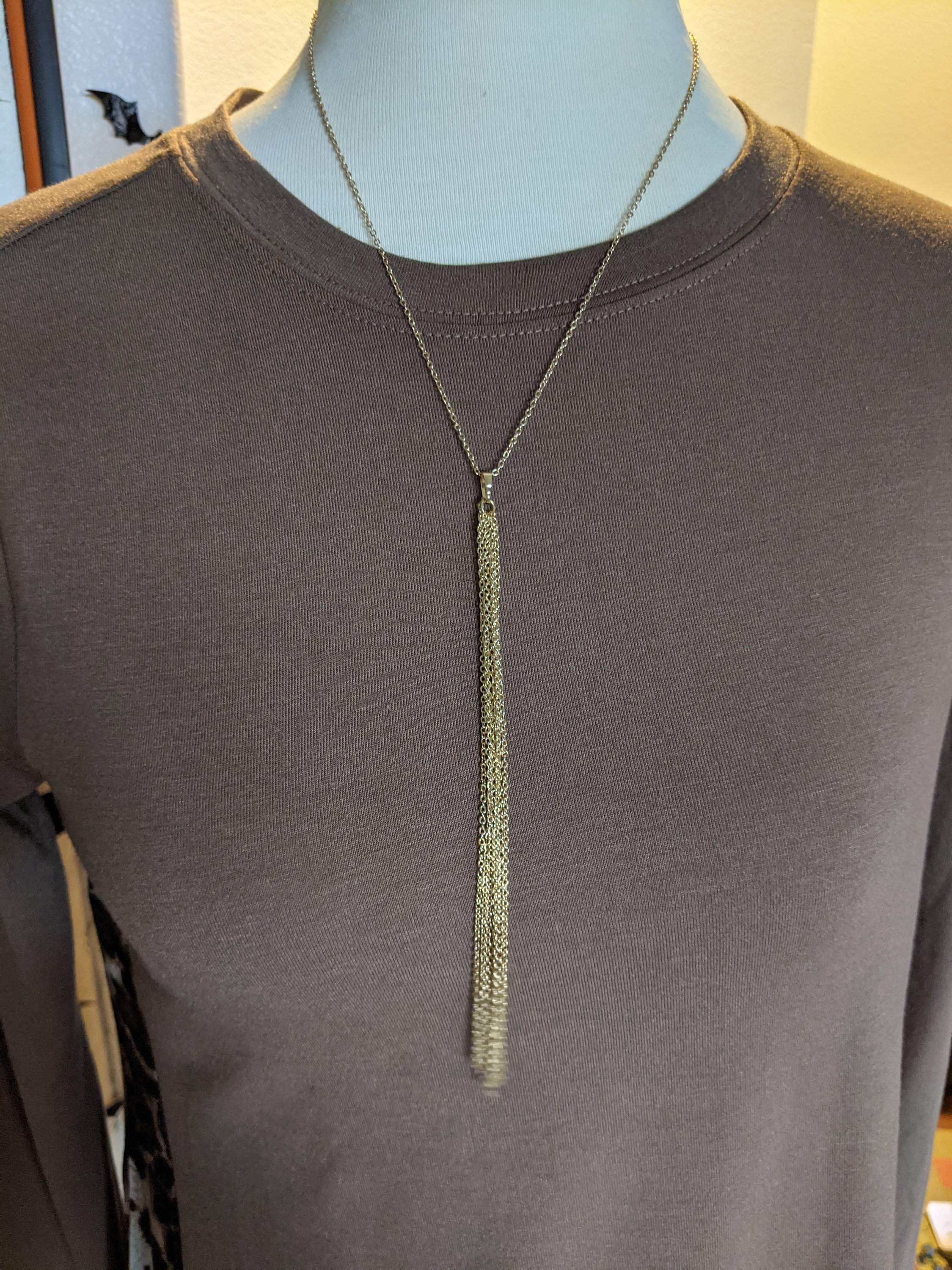 A stylish gold long tassel necklace featuring a delicate chain and a flowing tassel, perfect for enhancing any outfit.