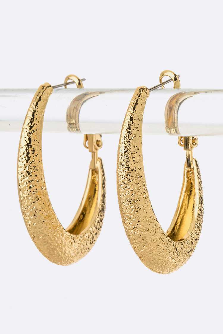 A pair of elegant gold textured hoop earrings showcasing a unique design and shine.