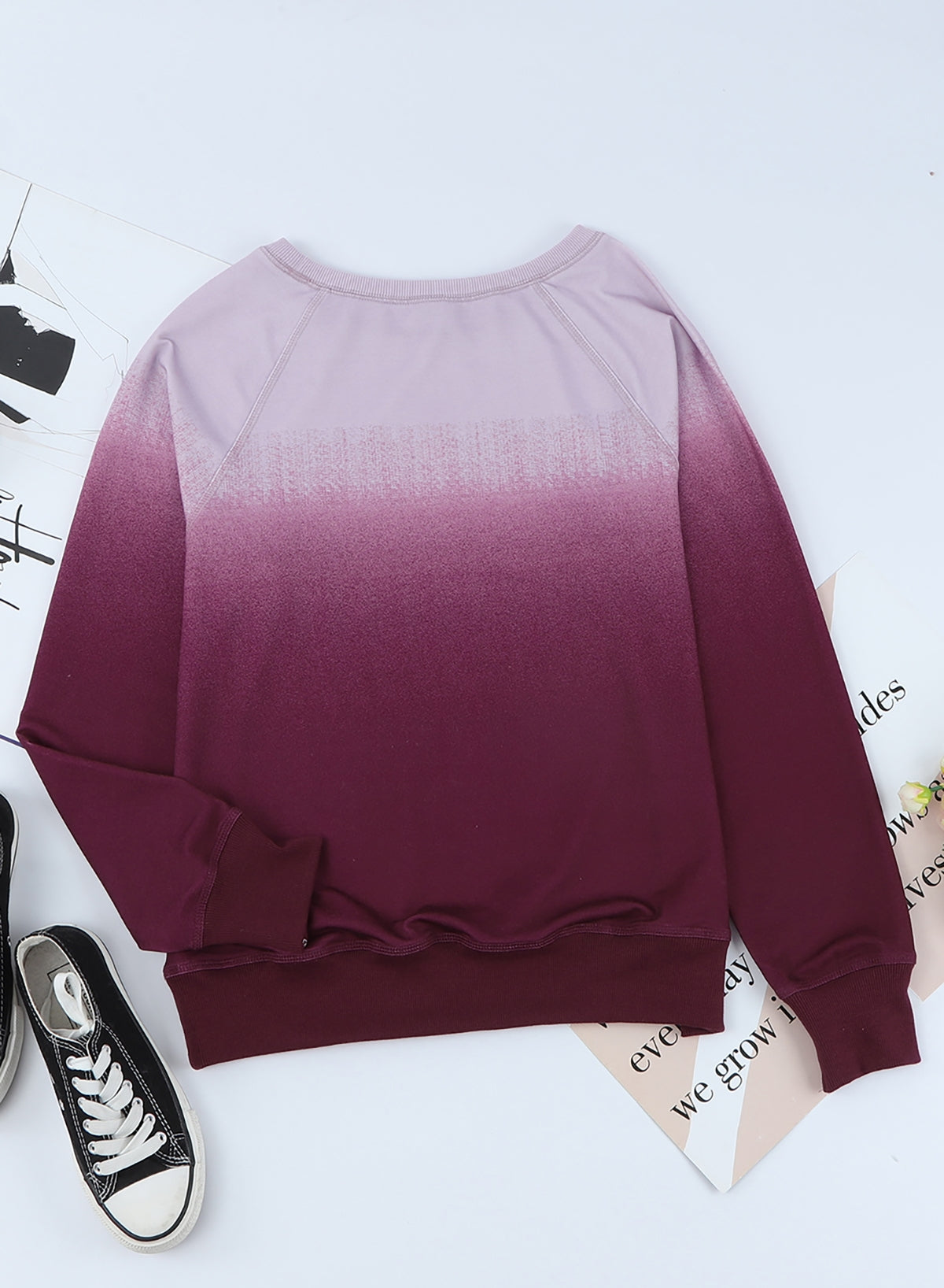 Gradient Raglan Sleeve Round Neck Sweatshirt displayed in a flat lay style, showcasing its unique gradient pattern and casual design.