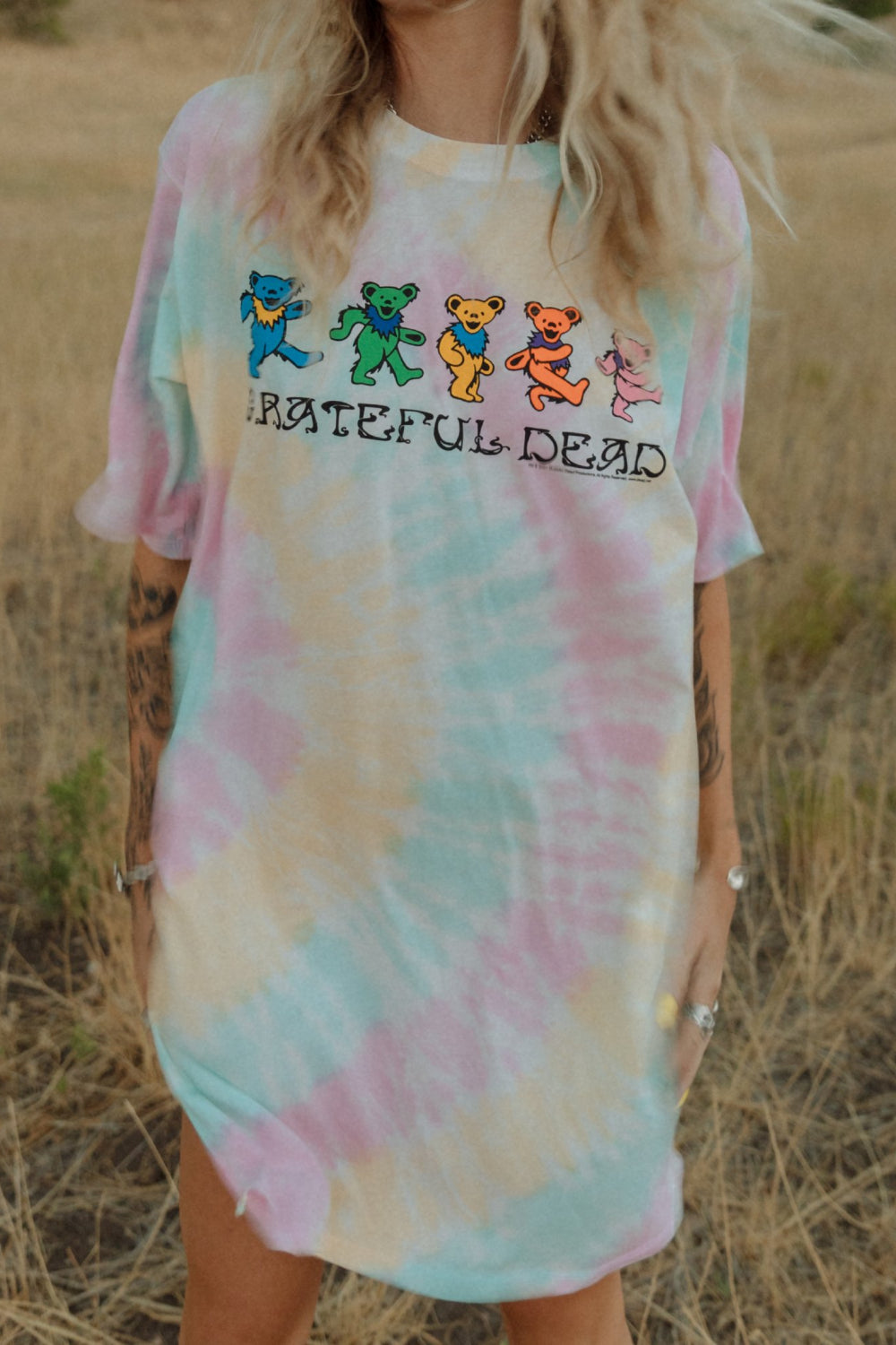 A colorful Grateful Dead Tee Dress Tie-Dye featuring a crewneck, side slit, and iconic bear graphic, made from organic cotton.