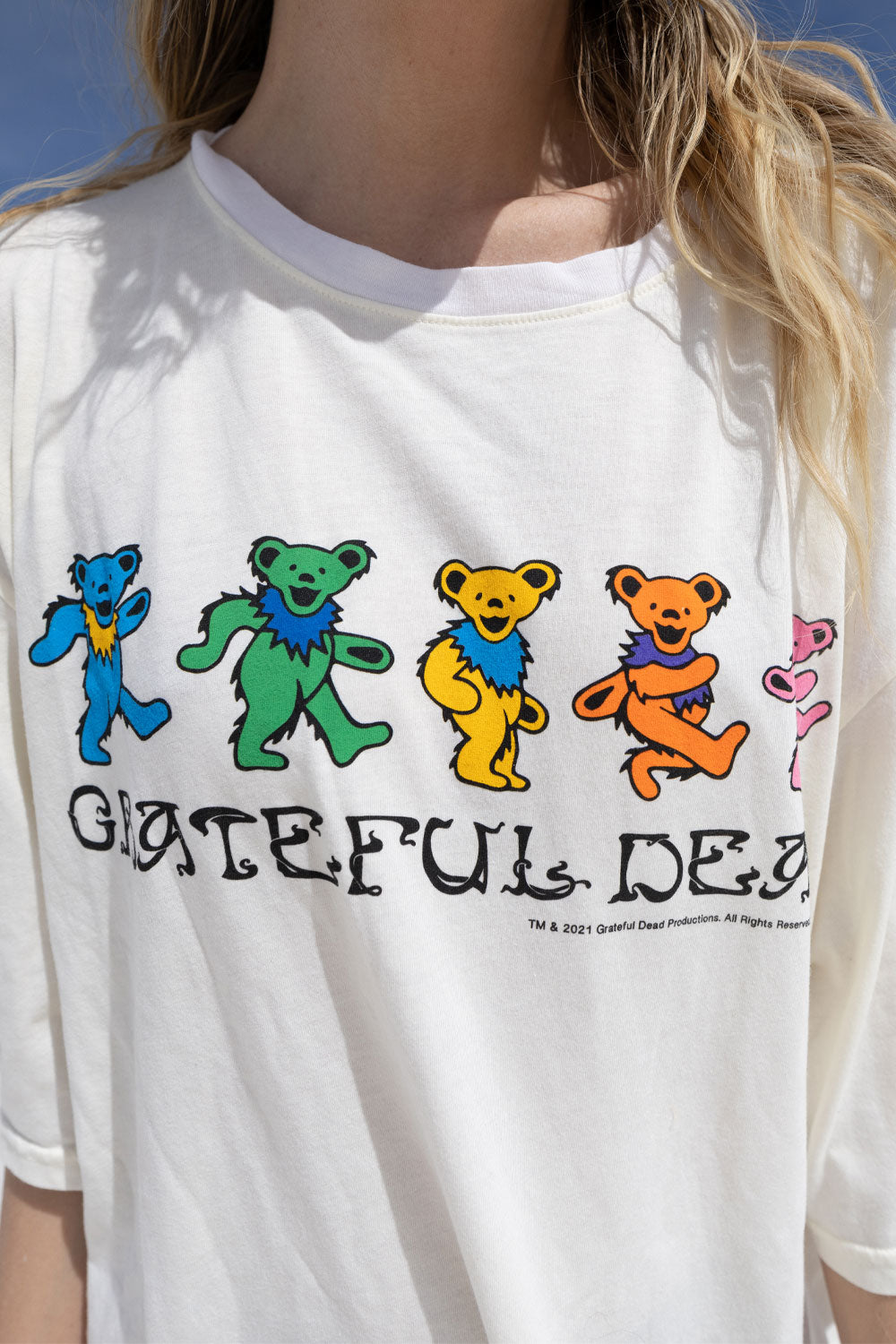 A vibrant Grateful Dead Tee Dress featuring a colorful tie-dye print, knee length, crew neck, and side slit, showcasing the iconic Grateful Dead Bear graphic.