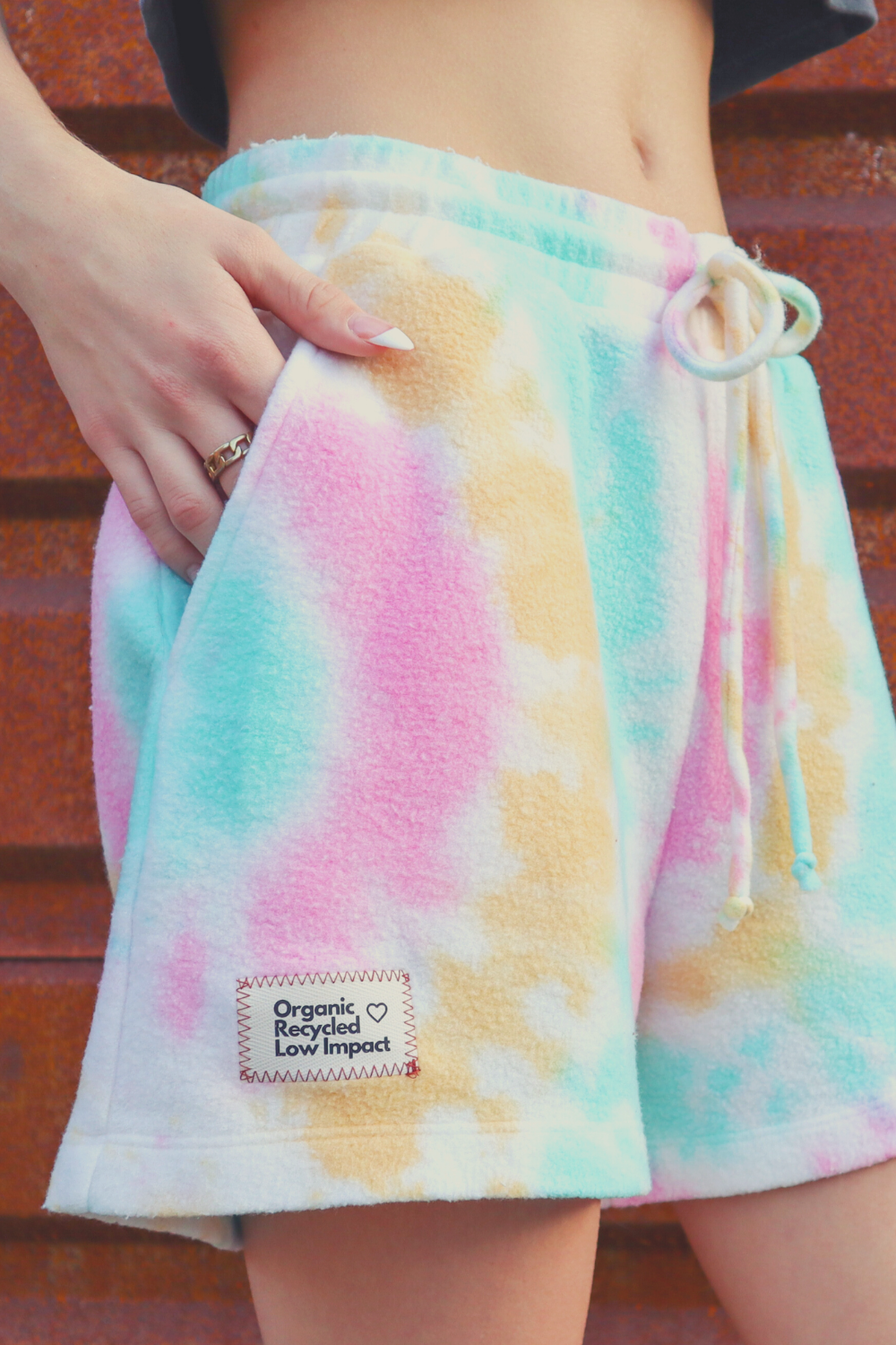 A pair of vibrant tie-dye shorts in Malibu and Miami colors, made from eco-friendly plush fleece fabric, featuring a drawstring waist and trouser pockets.